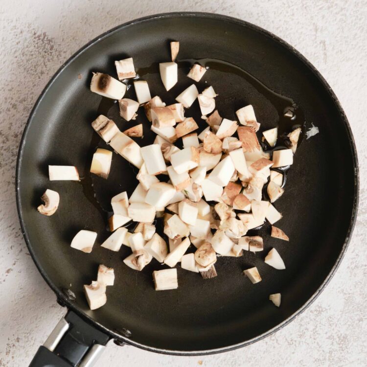 Sliced mushrooms cooking in a frying pan for a delicious recipe.