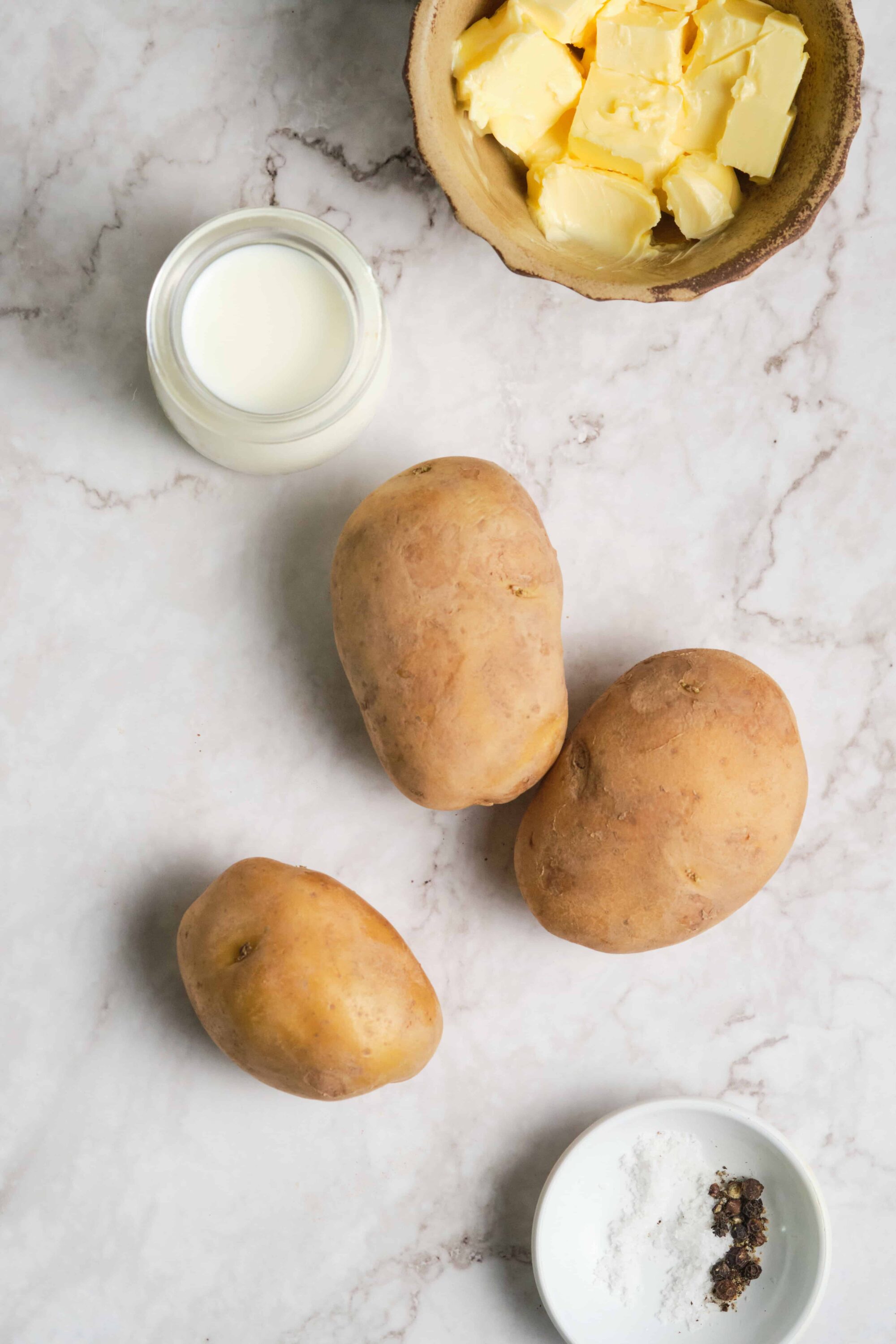Creamy milk, butter, potatoes, and seasonings ready for a delicious baked potato recipe.