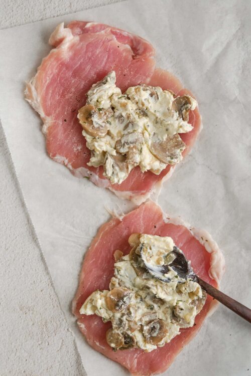 Fresh chicken breast topped with creamy mushroom and herb filling, ready for baking.