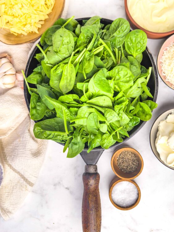 Fresh spinach leaves in a skillet, ready for cooking or salad.