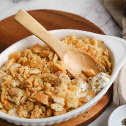 Butter crust apple cobbler in white baking dish with wooden spoon and fresh baked crust topping, homemade dessert, baked bree.