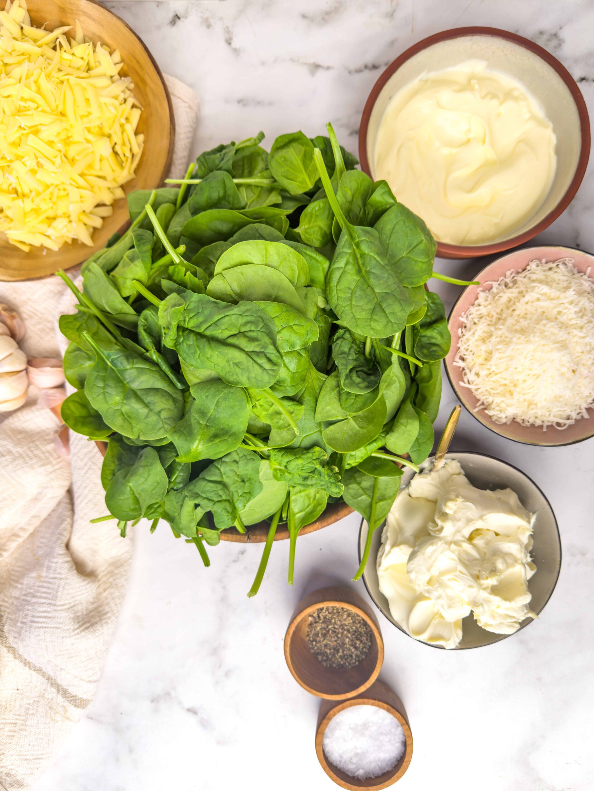 Fresh spinach leaves with cheese, cream, and seasonings for a delicious spinach dip recipe.