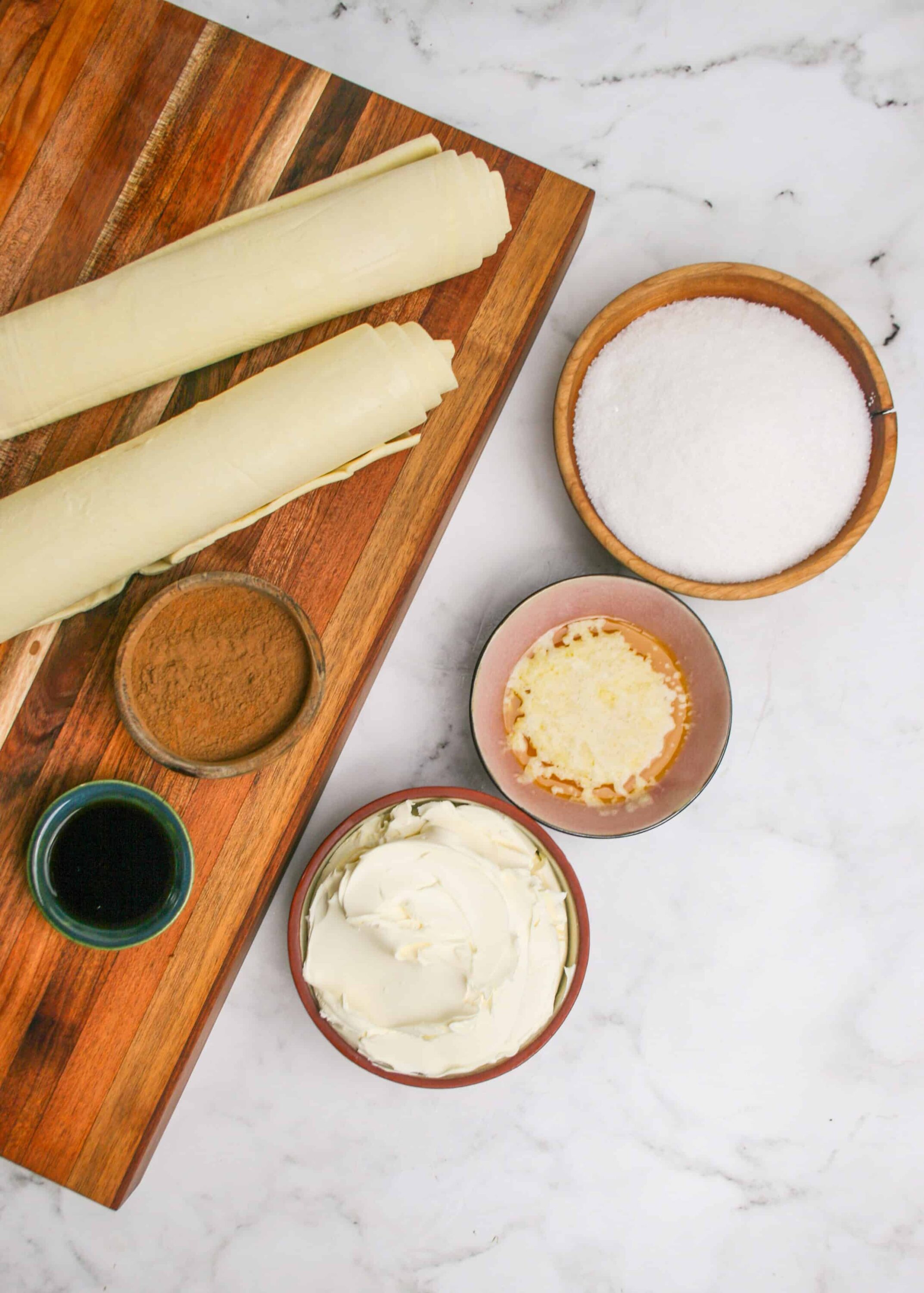 Close-up of puff pastry ingredients and fillings on a marble surface.