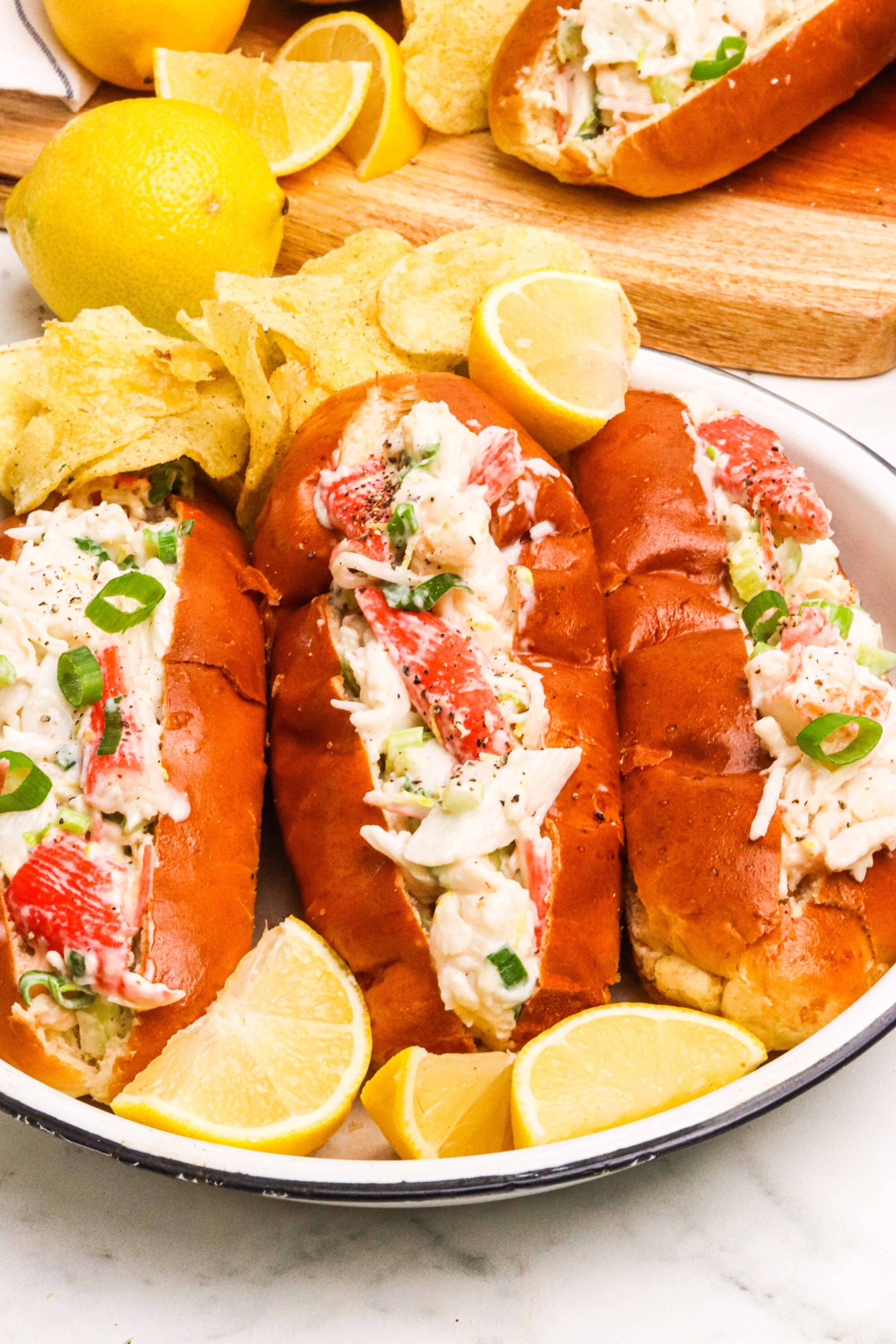 Buttery lobster rolls with fresh seafood, served with lemon wedges and crispy chips. Perfect for seafood lovers and summer picnics.