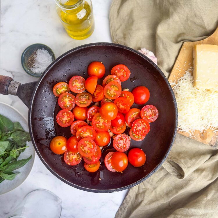Fresh cherry tomatoes cooking in a skillet for a Italian pasta sauce.