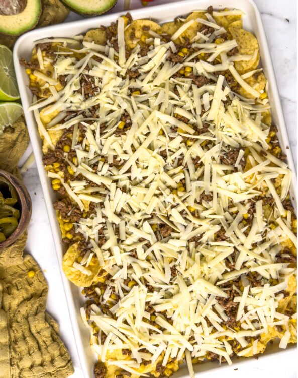 Cheesy beef and corn casserole baked in white dish, shredded cheese topping, baked Bree recipe, easy comfort food recipe, savory casserole dish.
