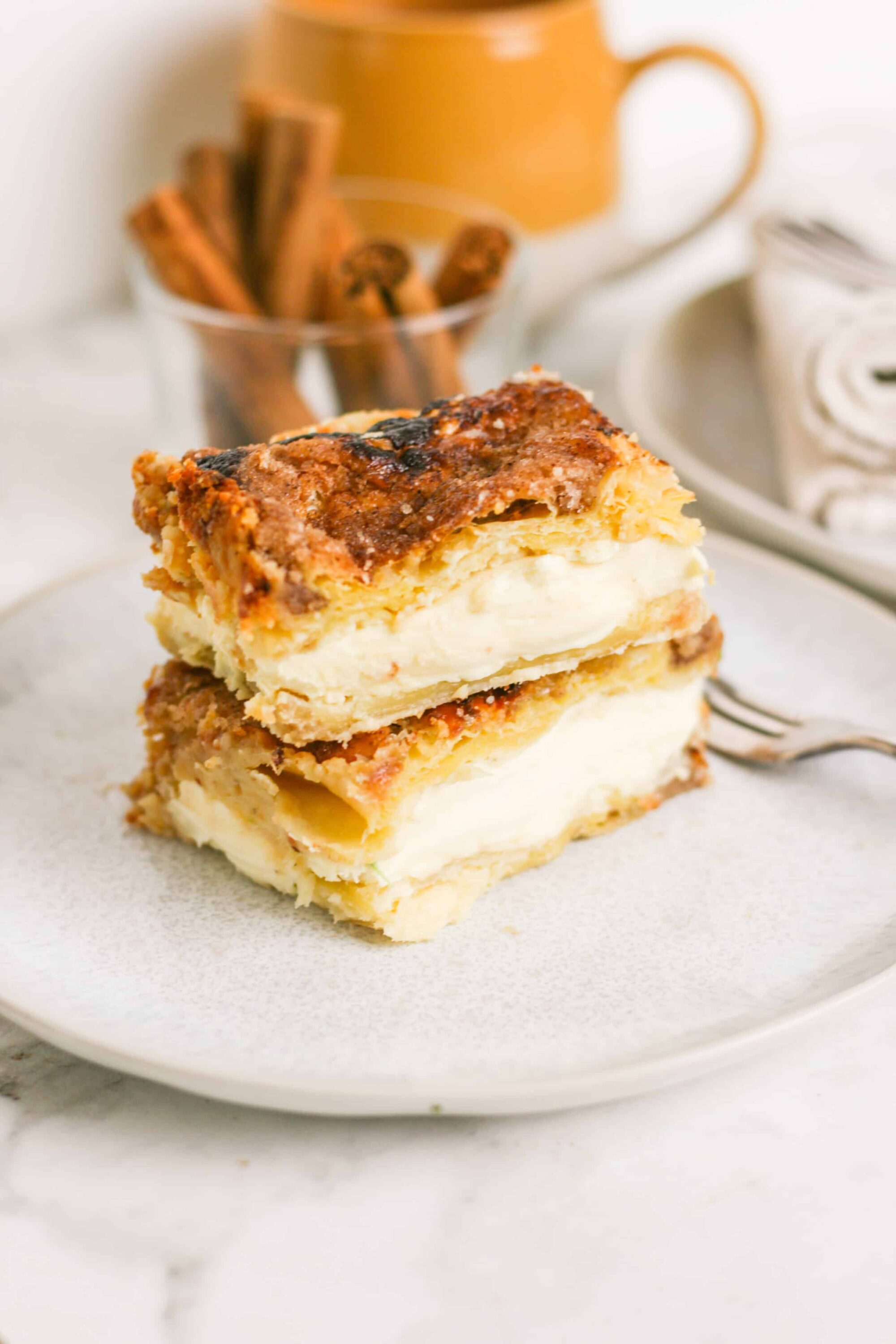 Buttery homemade cream pie with a golden flaky crust and creamy filling on a white plate.