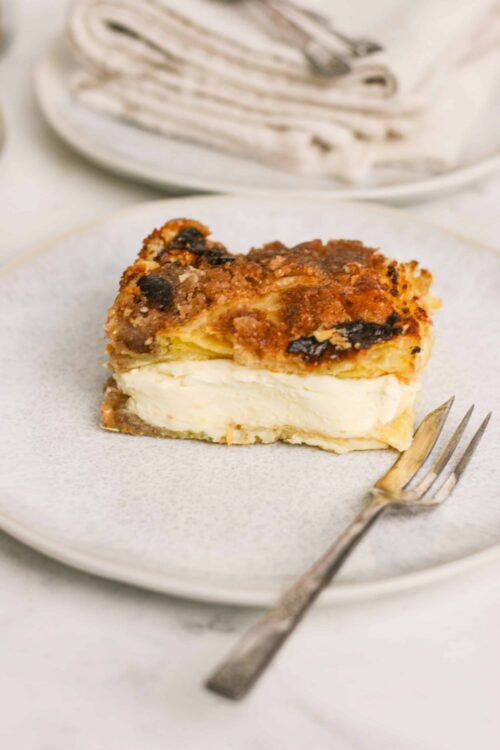 Butter crust apple crumble pie with vanilla ice cream on white plate.