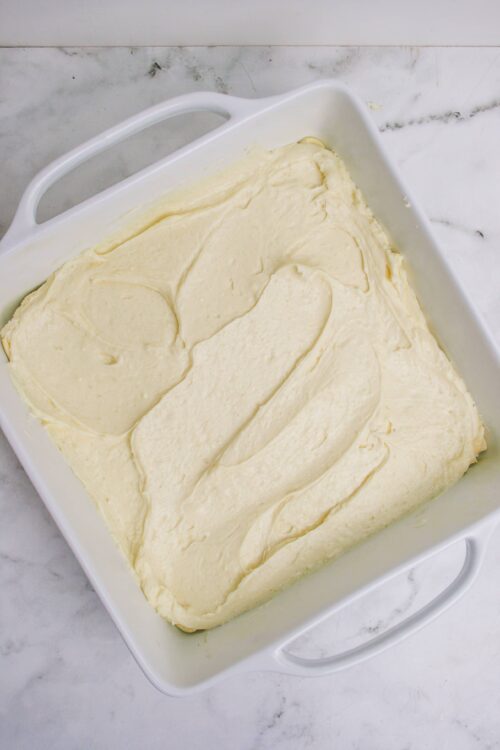 Fluffy vanilla cake batter in a white baking dish before baking.