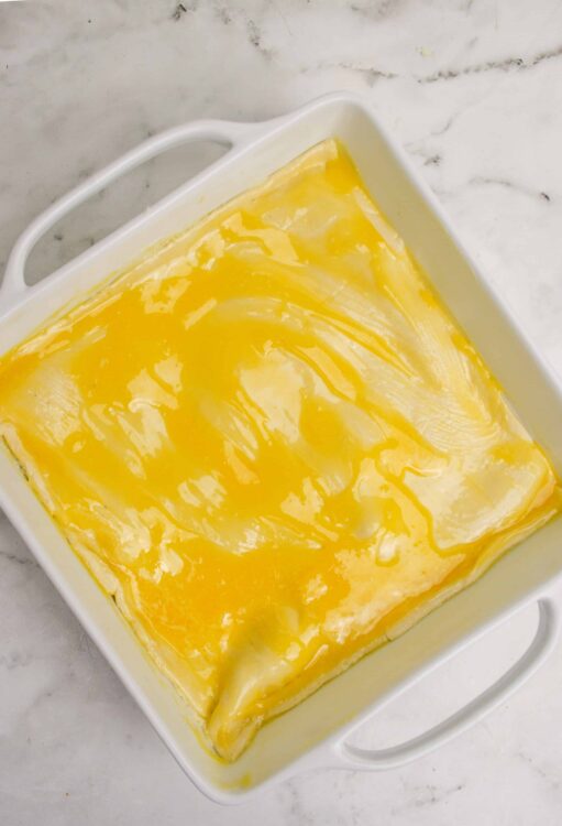 Rich, creamy lemon custard filling in a white baking dish for lemon bars.