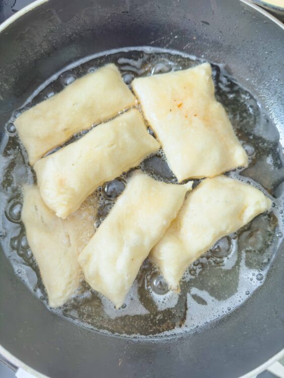 Golden fried cheese sticks cooking in a skillet, crispy and delicious appetizer, perfect for snacking or party food, from Baked Bree.