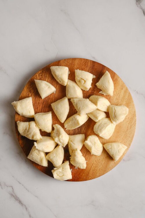 Creamy homemade gnocchi on a wooden board, ready to be cooked, with a soft texture and authentic Italian flavor.