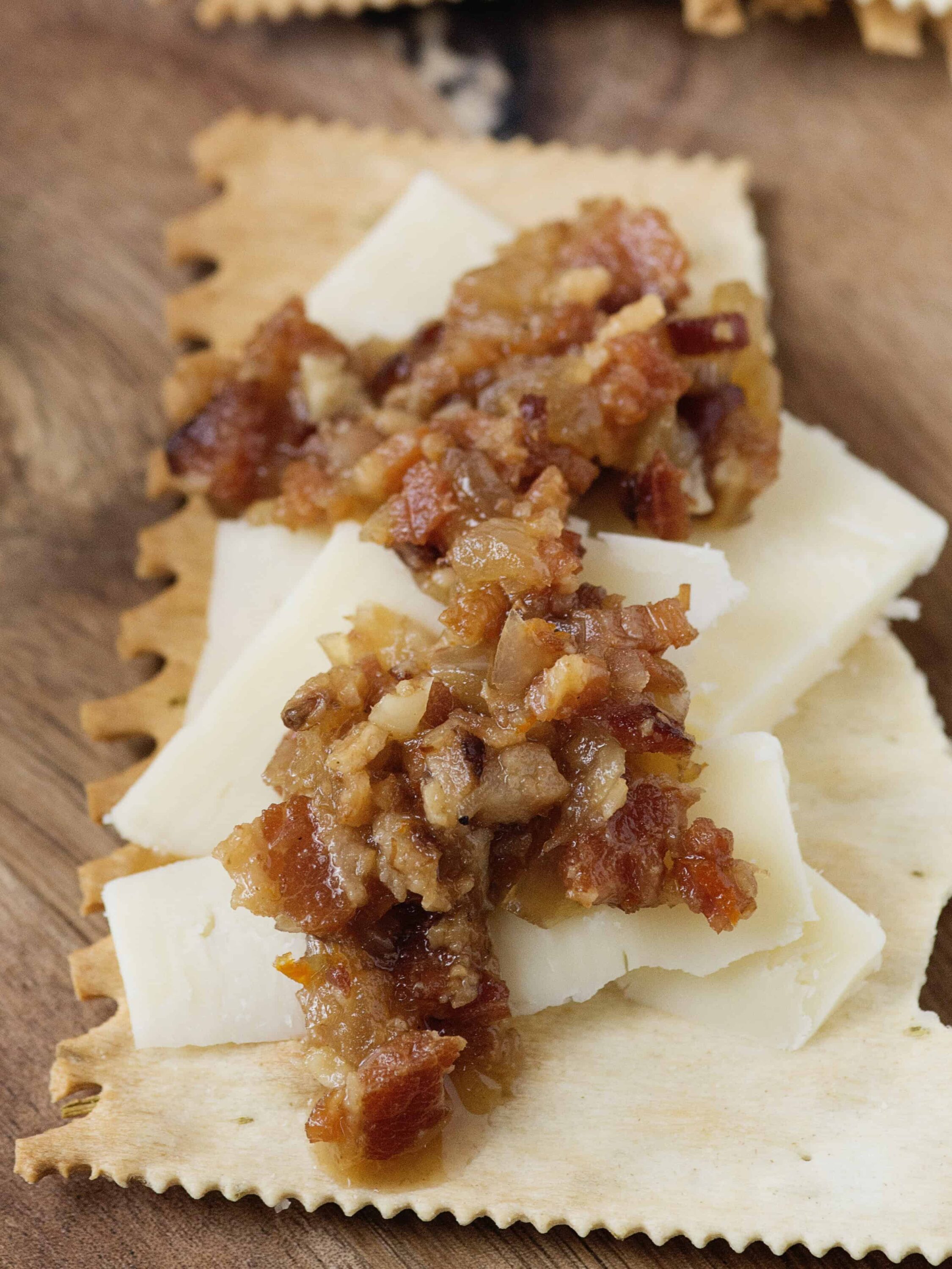 Savory bacon and onion chutney on creamy cheese slices on crisp crackers.