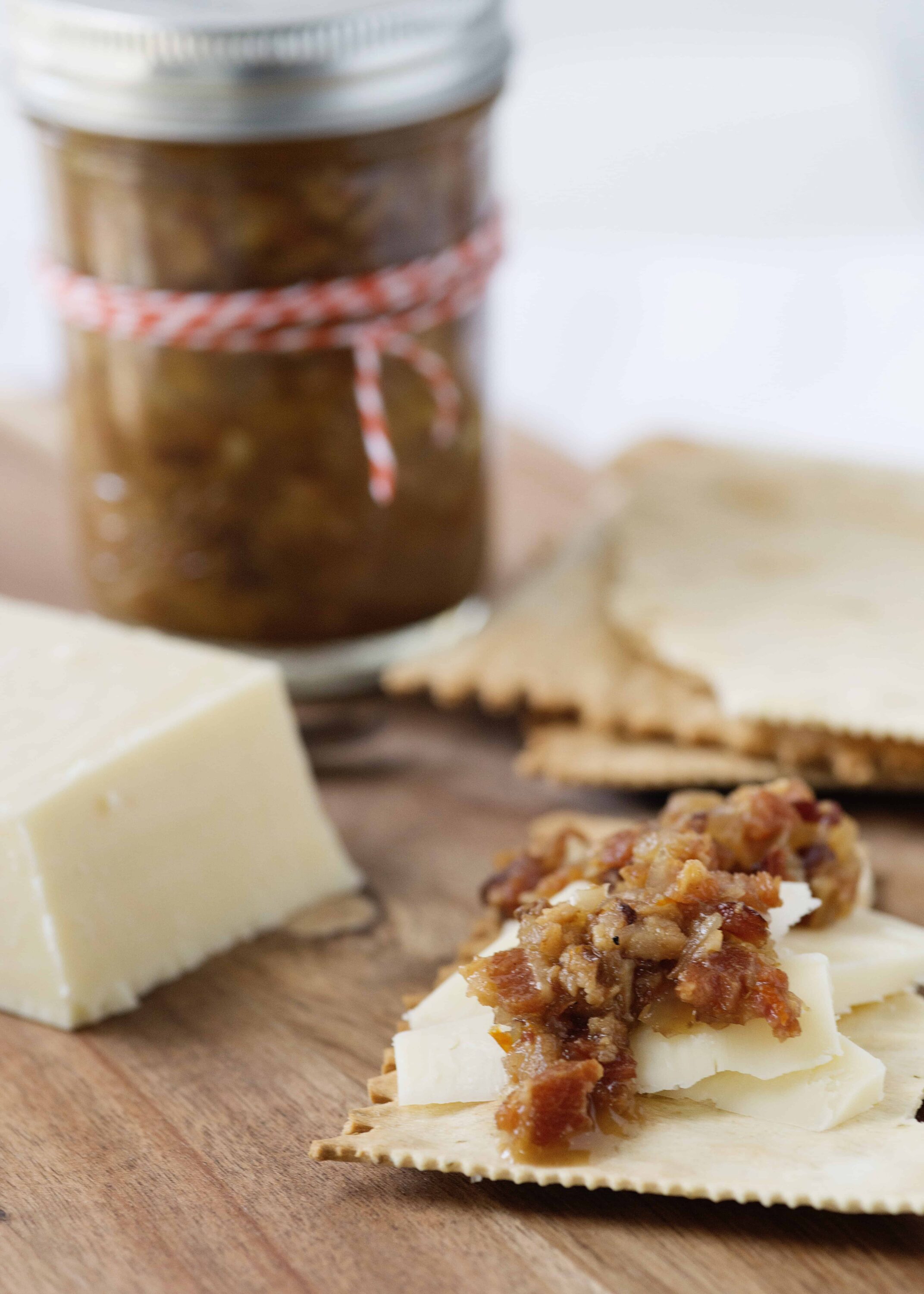 Creamy brie cheese with savory bacon jam on crispy flatbread. Perfect appetizer with cheese and charcuterie for entertaining.