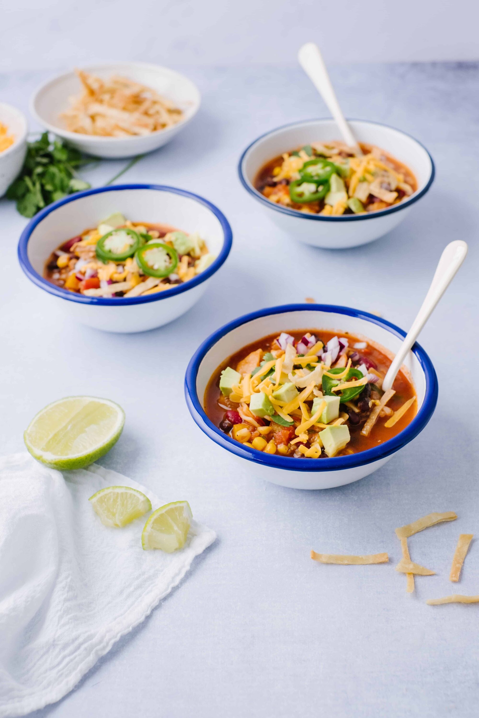 Creamy taco soup with shredded cheese, avocado, and jalapeños in bowls. Perfect for a comforting, flavorful meal.