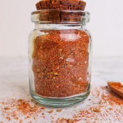 Ground spice blend in a glass jar with a cork lid, ideal for baking and cooking.