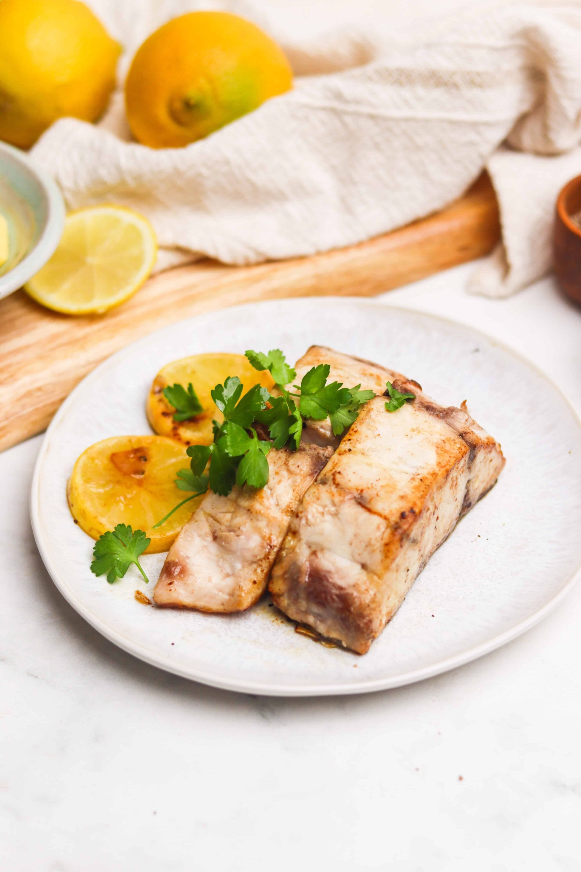 Juicy roasted fish fillet garnished with fresh herbs and lemon slices, perfect for healthy seafood recipes.