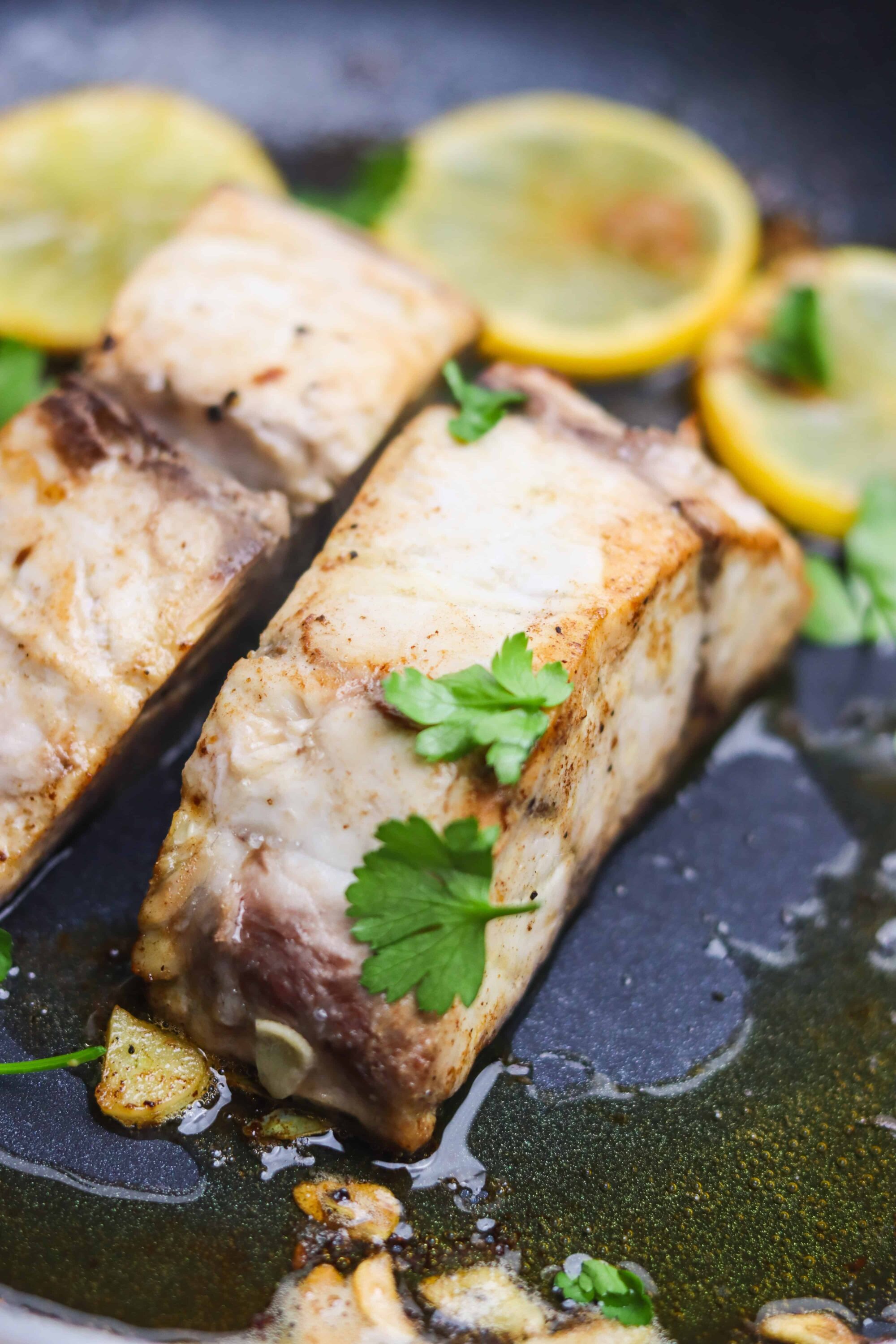 Juicy lemon herb fish fillets garnished with fresh cilantro and lemon slices. Perfect for healthy seafood dinners.