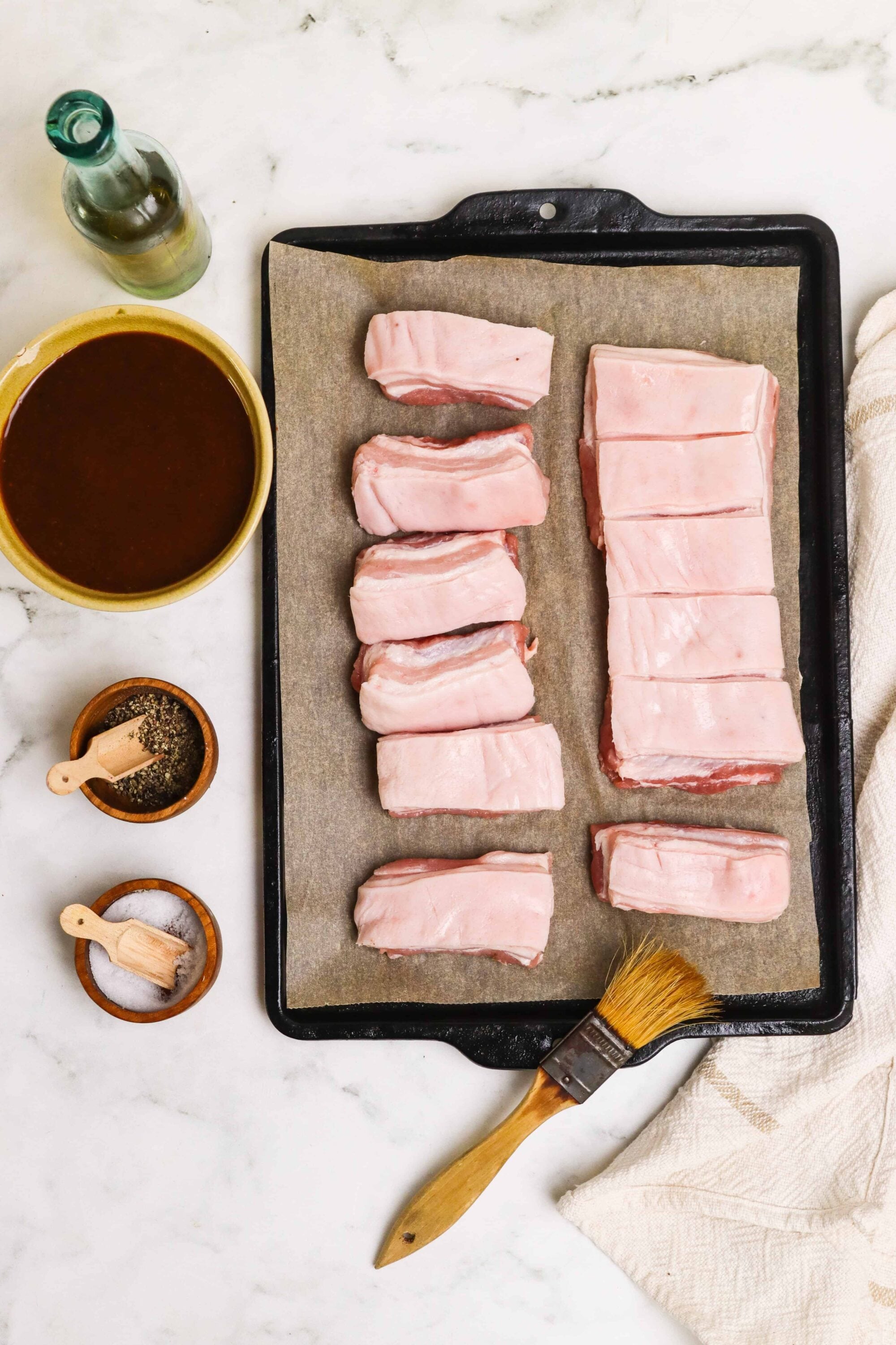 Succulent pork belly slices on a baking sheet ready for cooking.