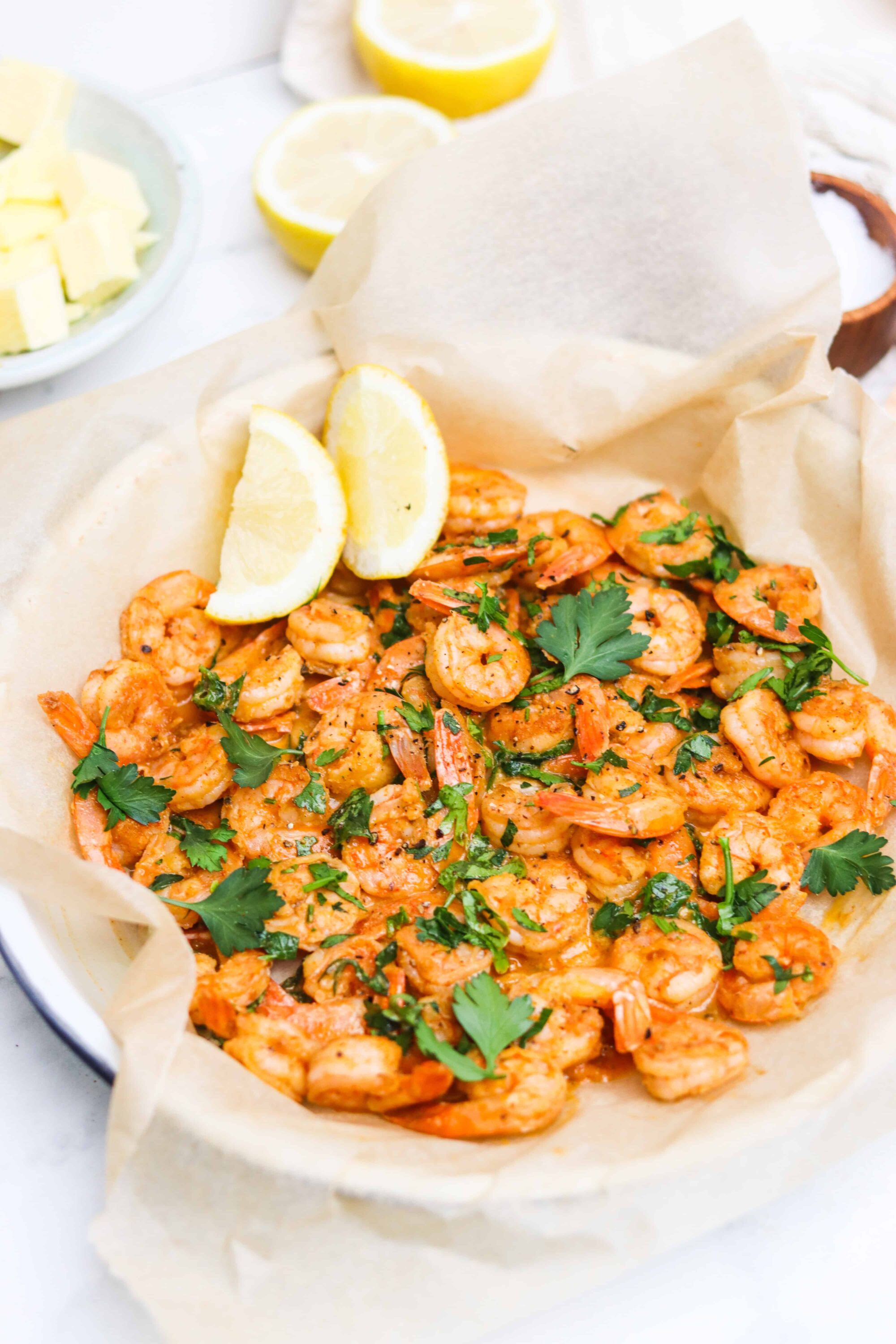 Juicy shrimp with lemon and fresh herbs served in parchment paper, perfect for seafood lovers.