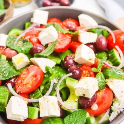 Fresh Greek salad with cherry tomatoes, feta cheese, cucumber, red onion, and olives.