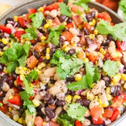 Fresh black bean and corn salad with diced tomatoes and cilantro in a ceramic bowl.