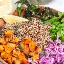 Roasted sweet potatoes broccoli quinoa salad in wooden bowl.