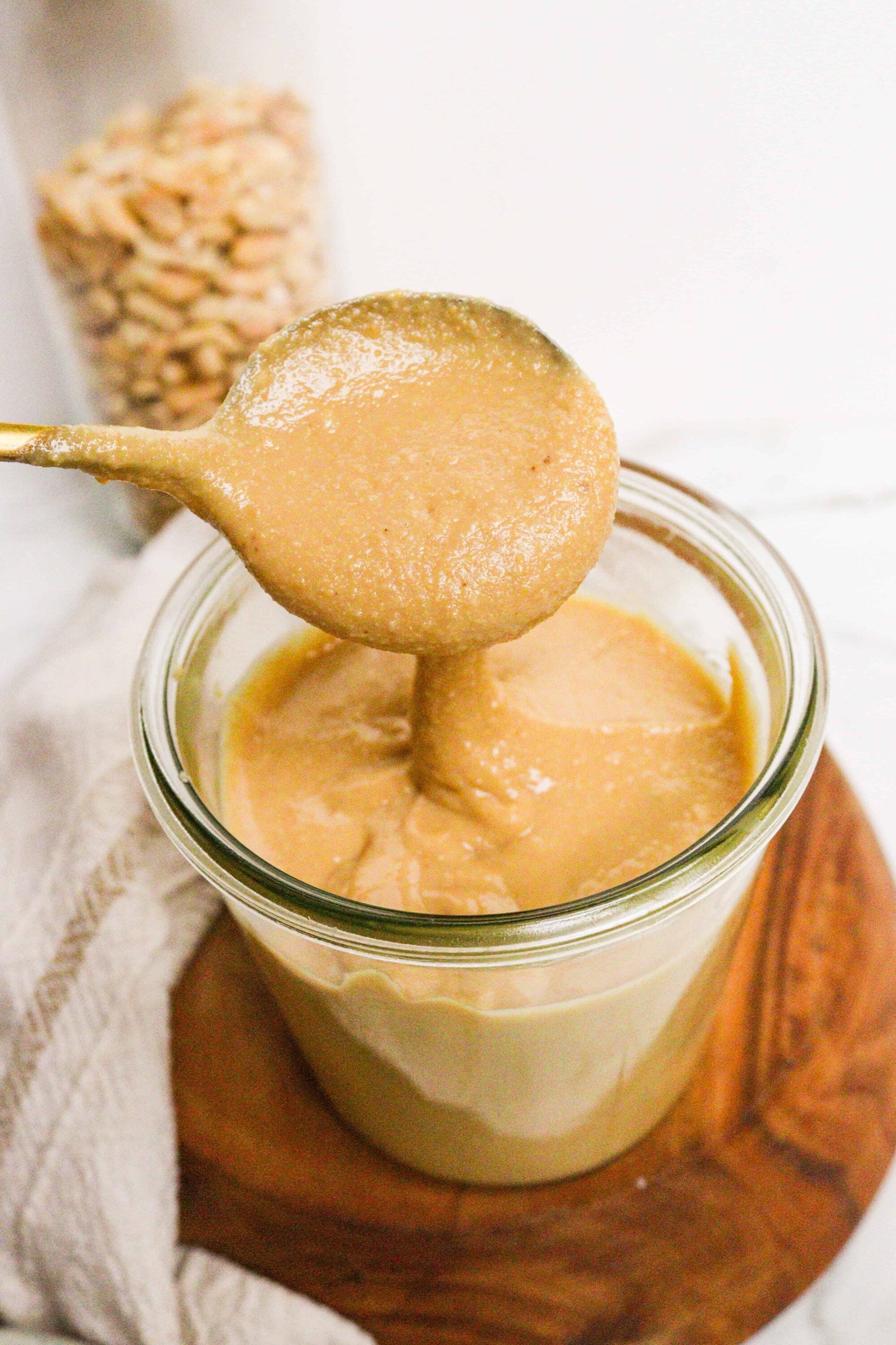 Creamy peanut butter porridge in a glass jar with a spoon, perfect for breakfast or snack.