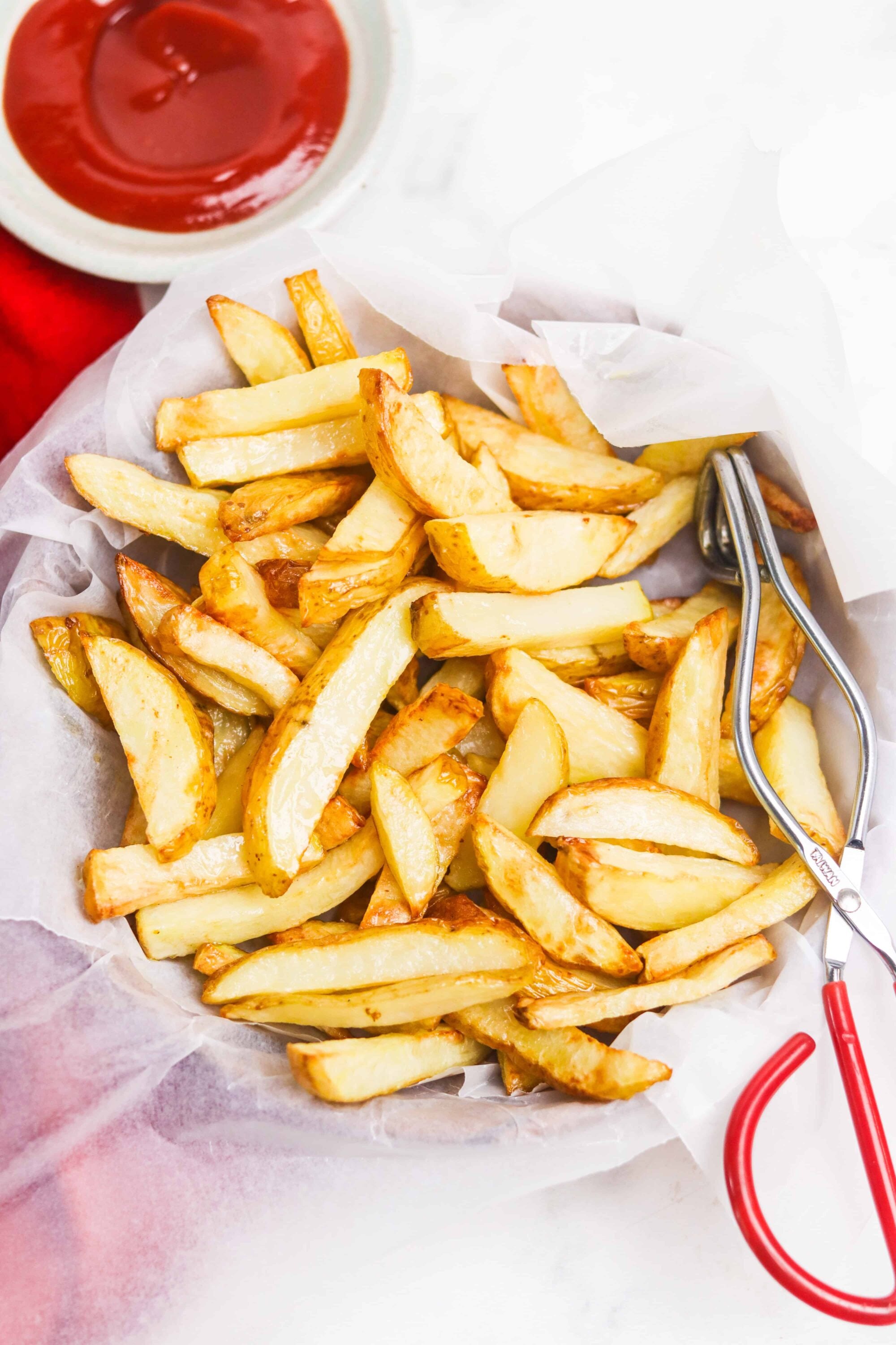 Crispy homemade French fries with golden edges served with ketchup. Perfect for a quick snack or side dish.