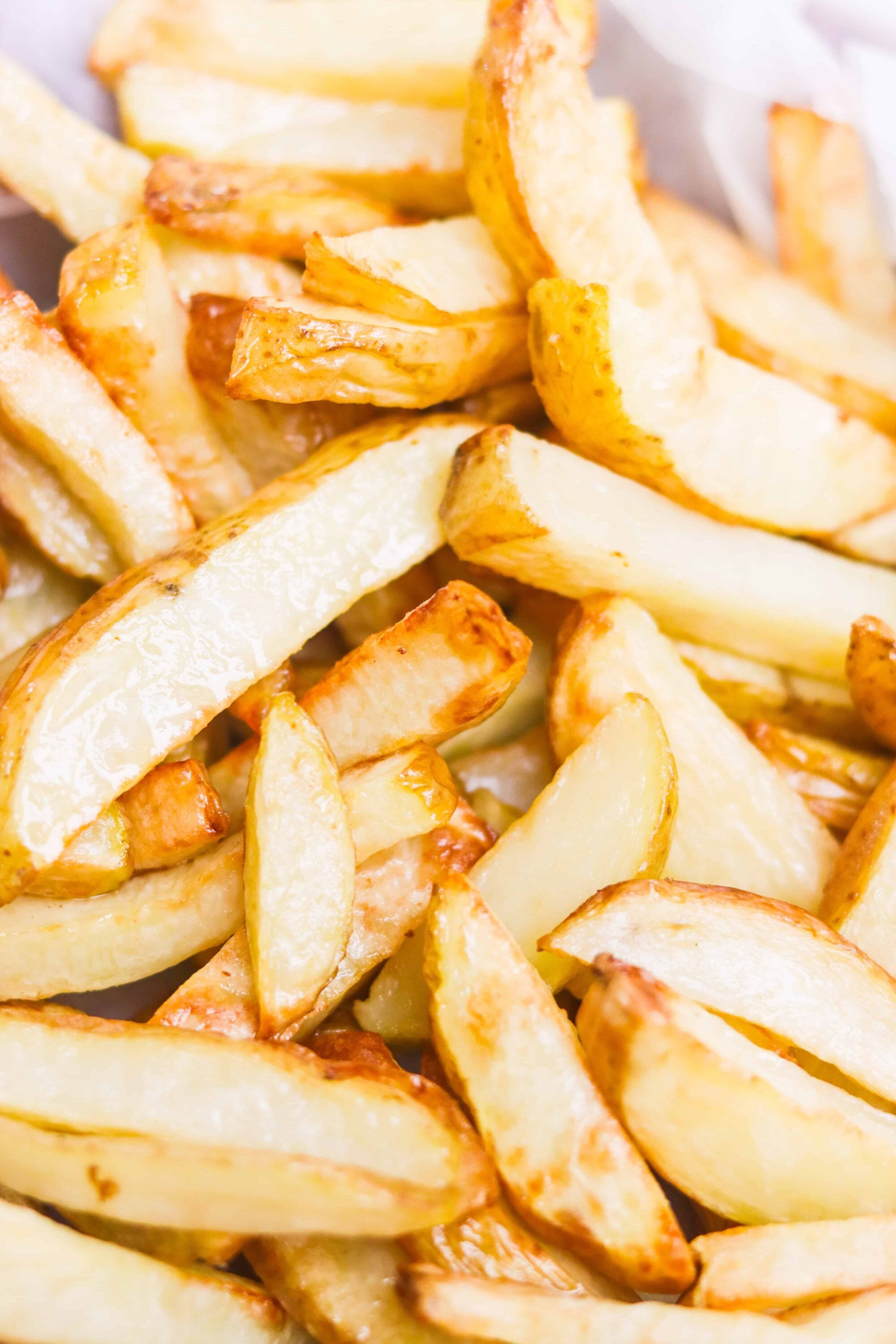 Crispy homemade French fries with golden-brown edges and seasoned potato wedges.