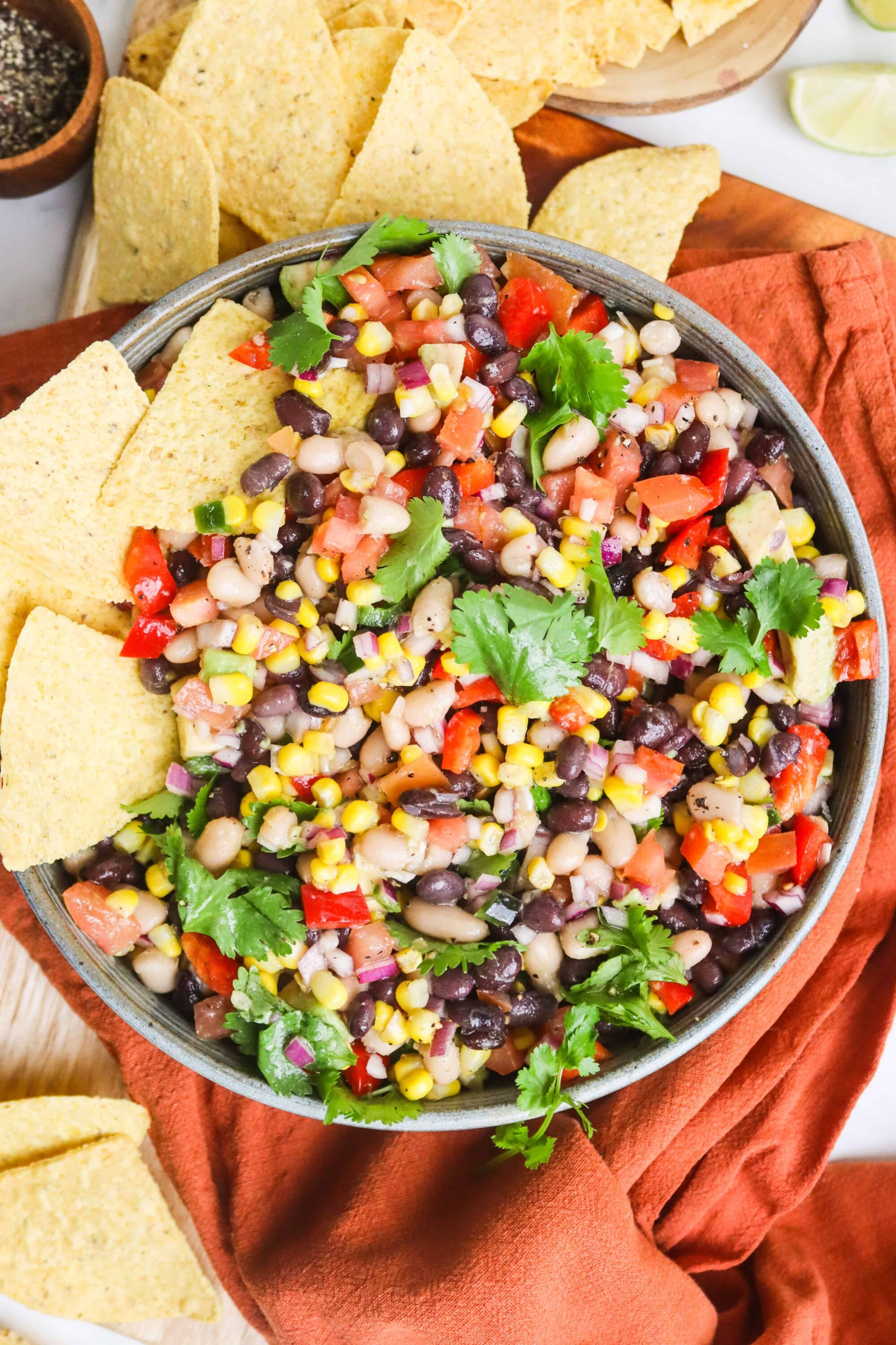 Fresh black bean and corn salad with chopped tomatoes and cilantro, served with tortilla chips.