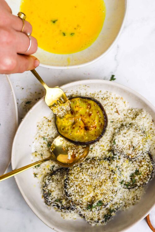 Creamy eggplant parmesan with shredded cheese and fresh herbs, ready to serve.