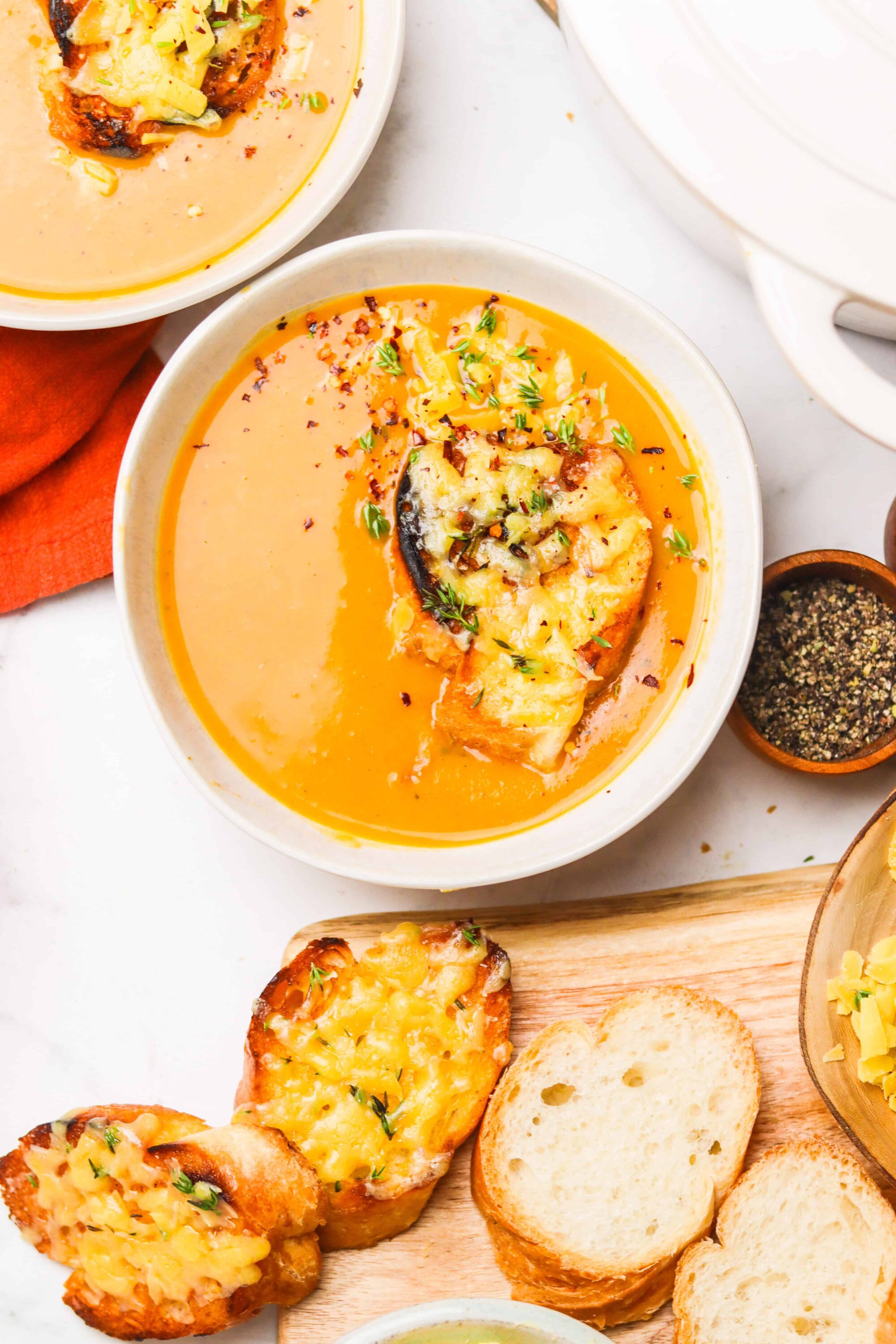 Creamy butternut squash soup served with toasted cheesy bread bites. Perfect for cozy fall meals and comfort food recipes.