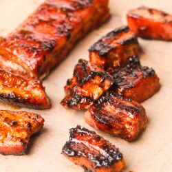 Smoked barbecue pork ribs on parchment paper with caramelized glaze.