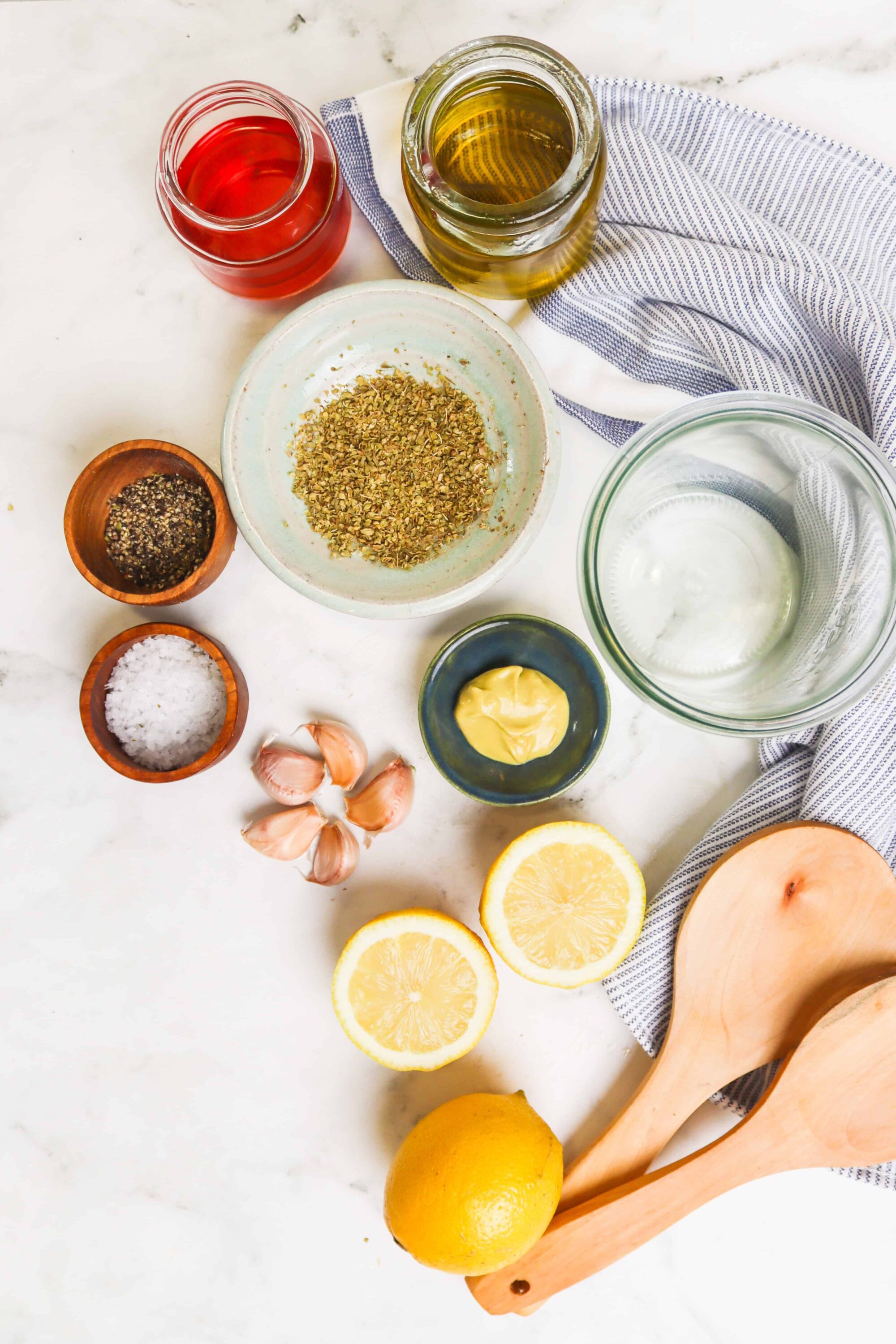 Fresh lemon juice, garlic, olive oil, herbs, and spices for homemade salad dressing.
