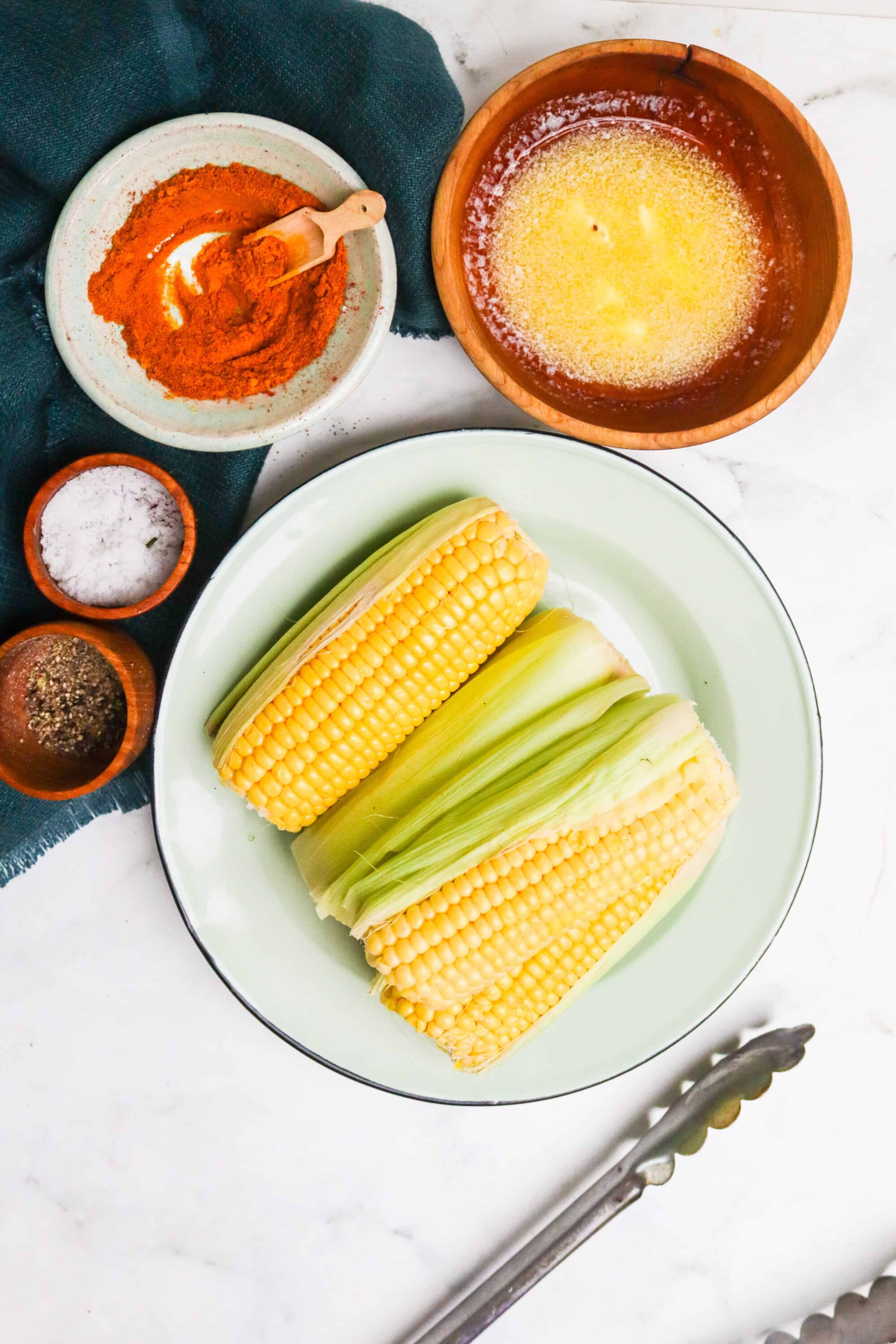 Fresh corn on the cob with seasonings and spices, perfect for summer grilling or cooking.