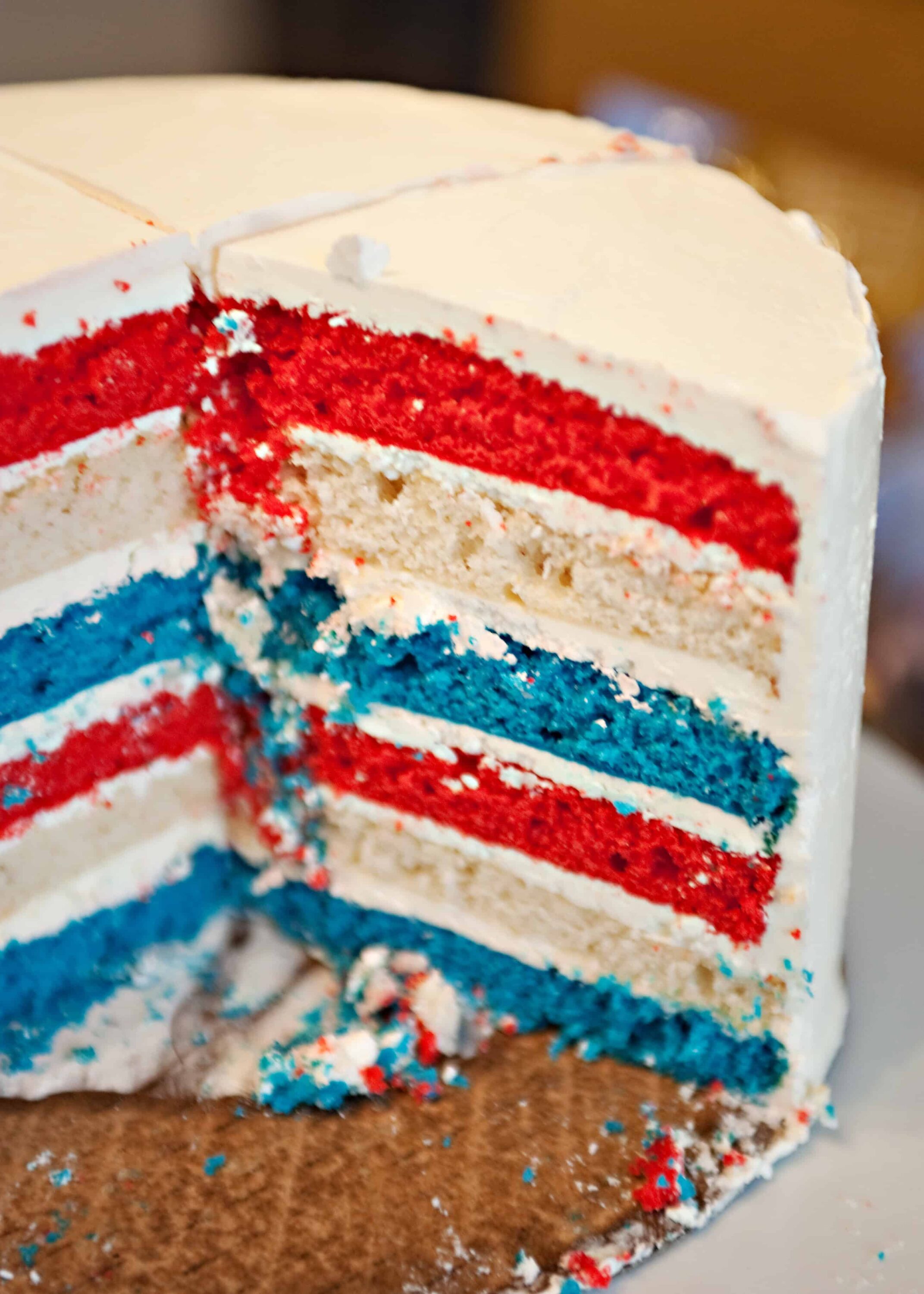 Bright red, white, and blue layered cake with colorful sprinkles, perfect for celebrations.