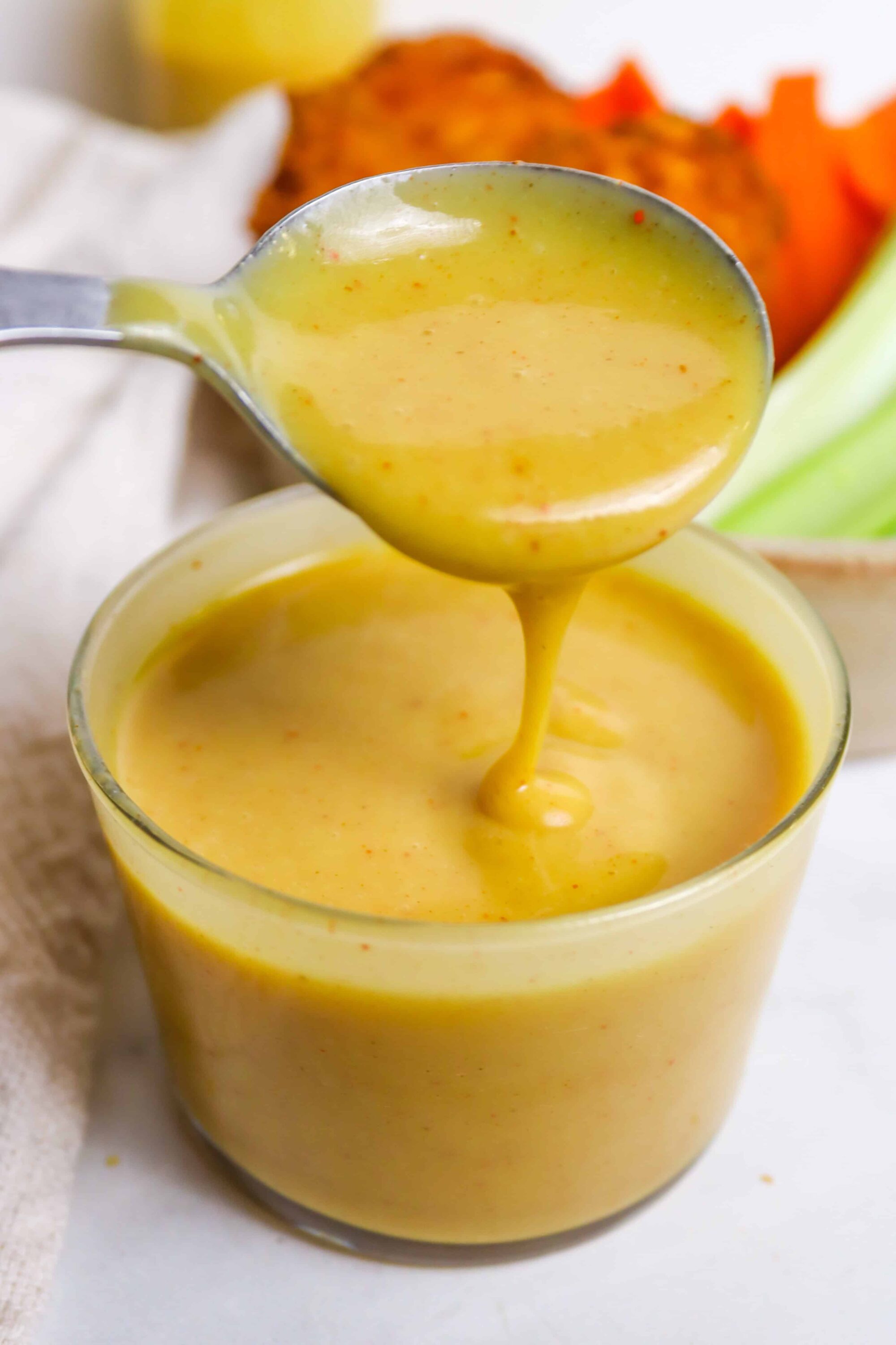 Creamy homemade yellow soup with spices, served in a glass, perfect for comforting recipes.