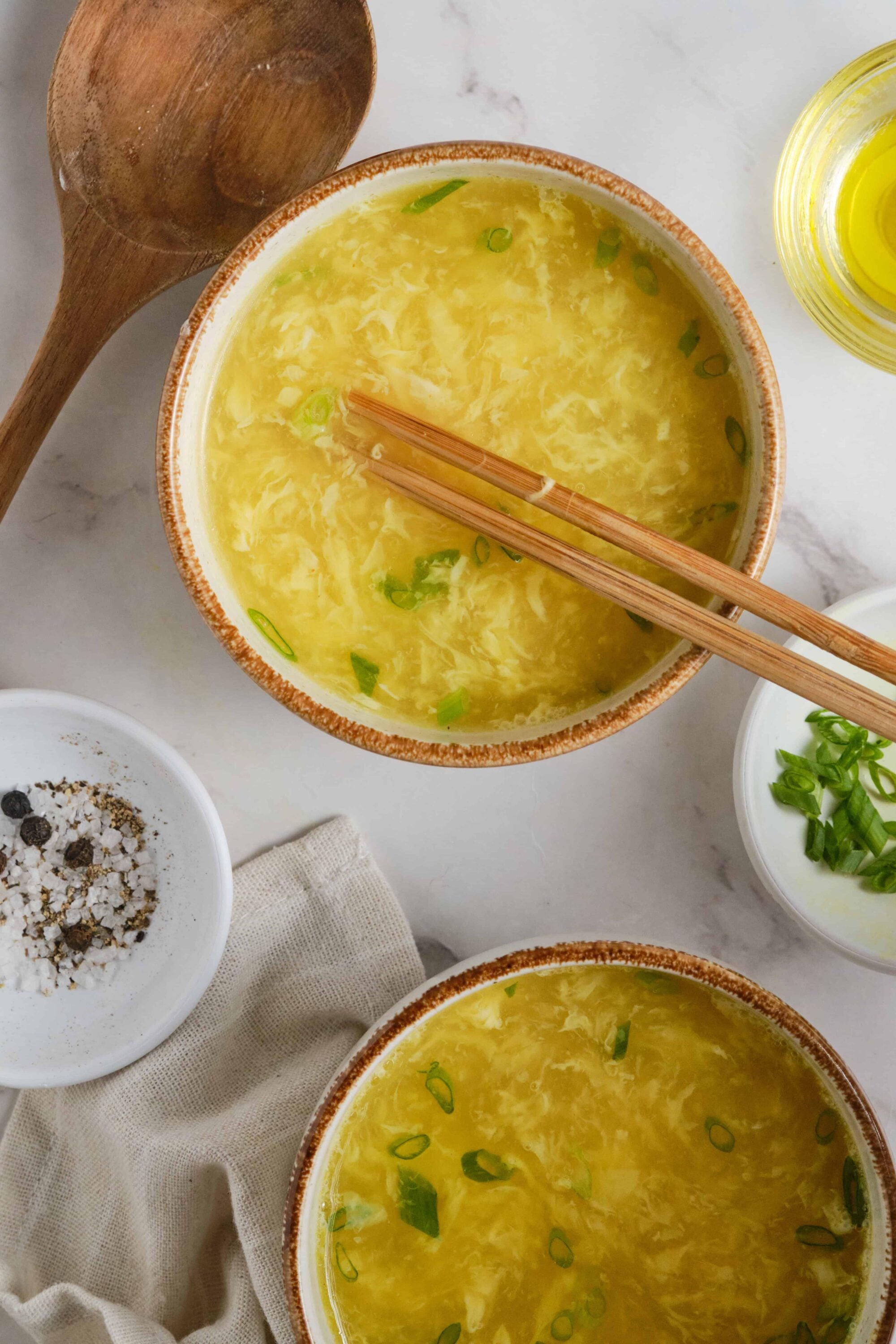 Creamy egg drop soup with chopped green onions served in rustic bowls. Perfect comfort food and easy recipe from Baked Bree.