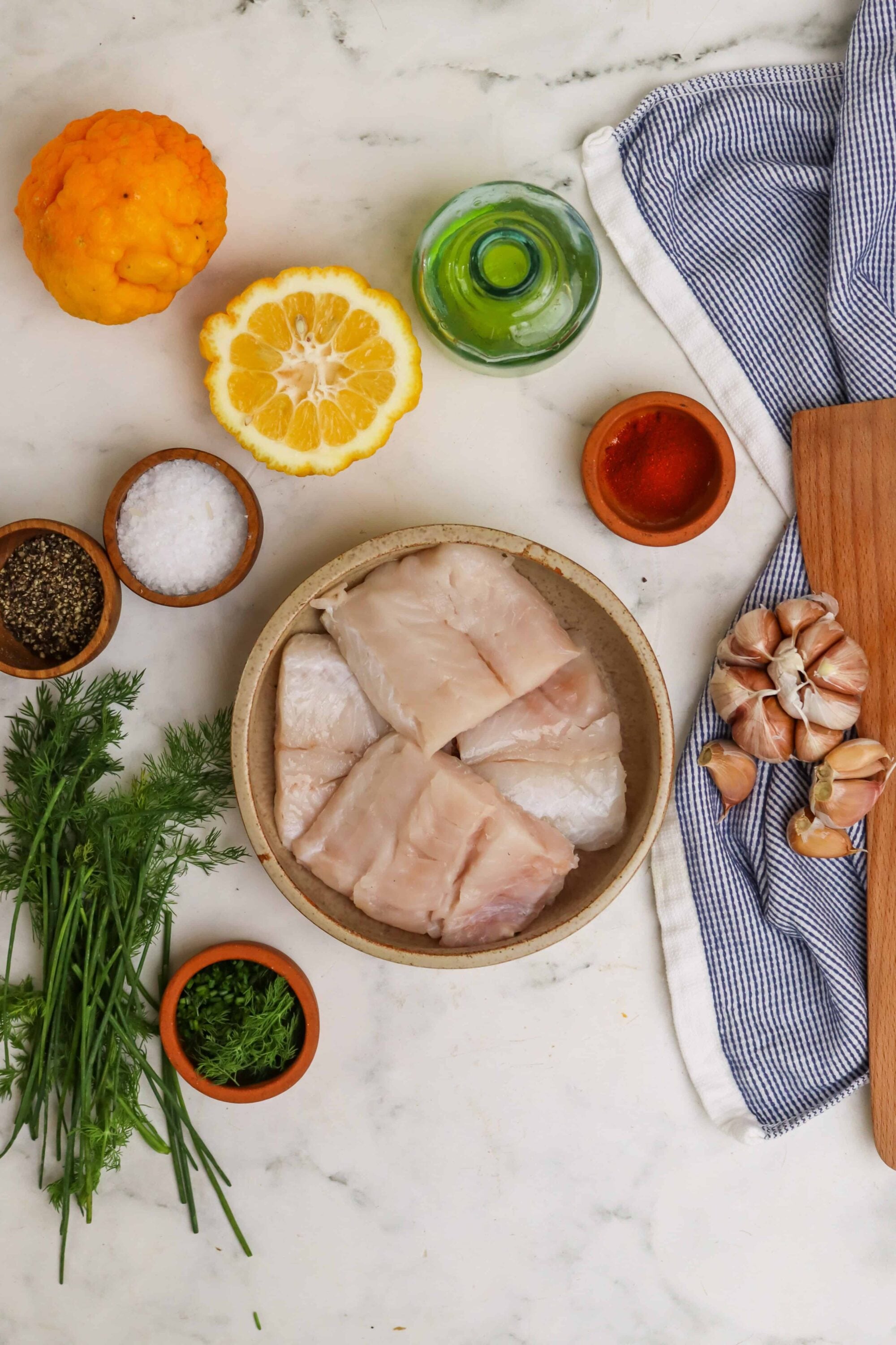 Juicy fish fillets with fresh herbs, lemon, garlic, and spices for healthy cooking and flavor enhancement.