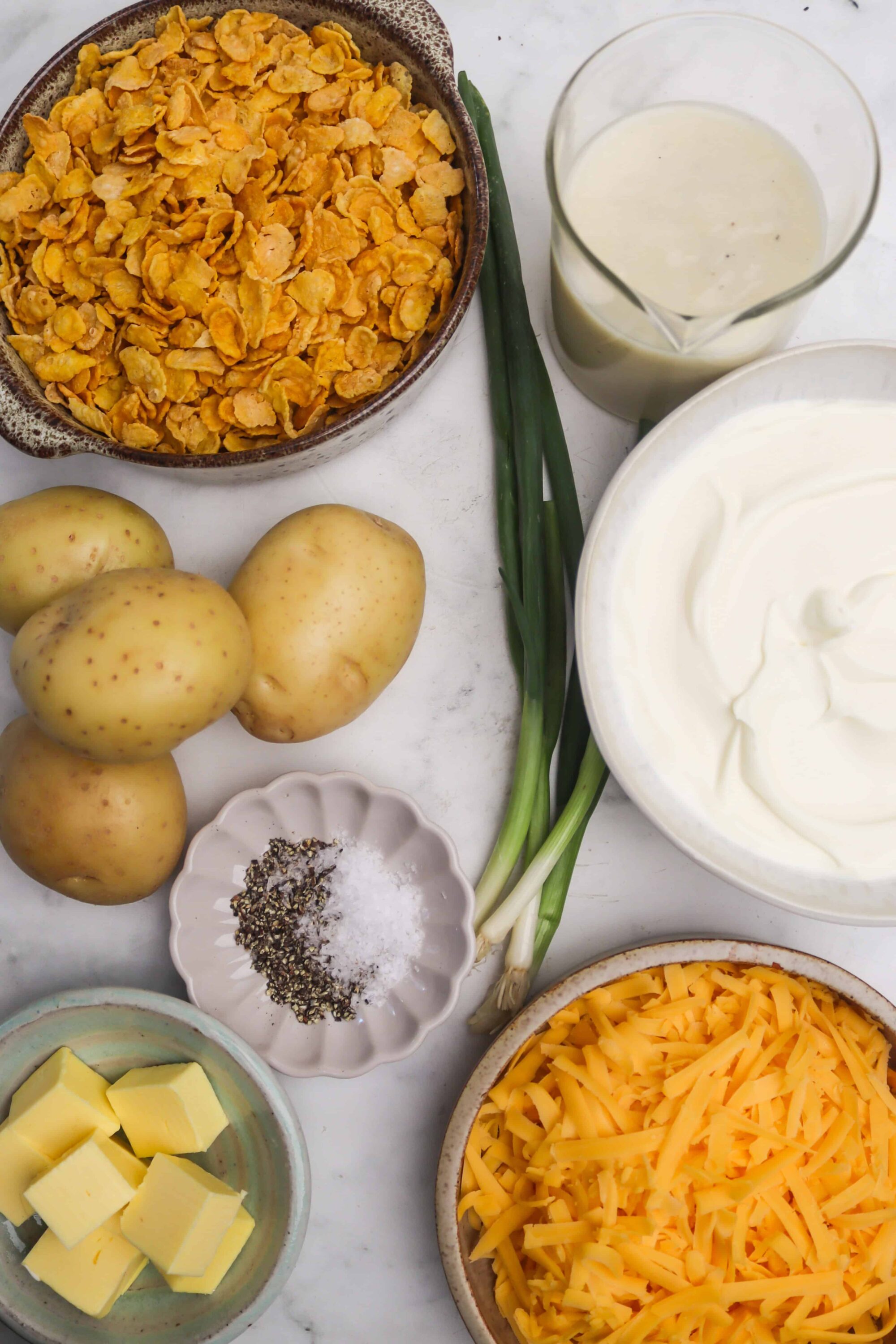 Golden hash browns ingredients for breakfast casserole, including cheese, potatoes, green onions, and dairy products.