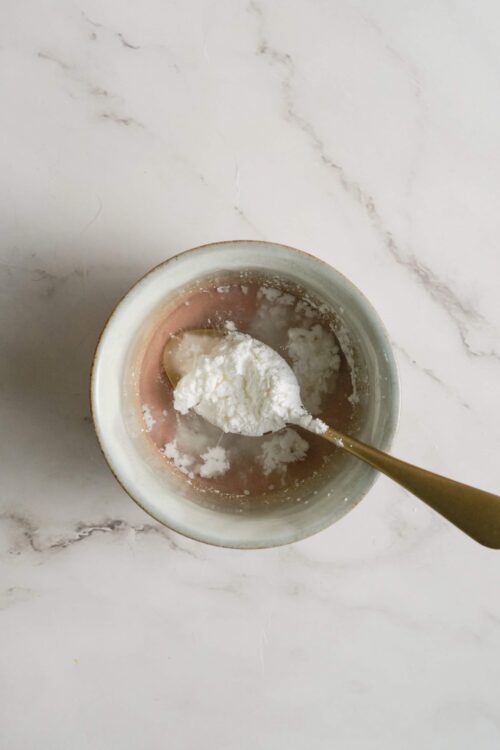 Creamy ricotta cheese in a small bowl with a spoon. Perfect for baking and dessert recipes.