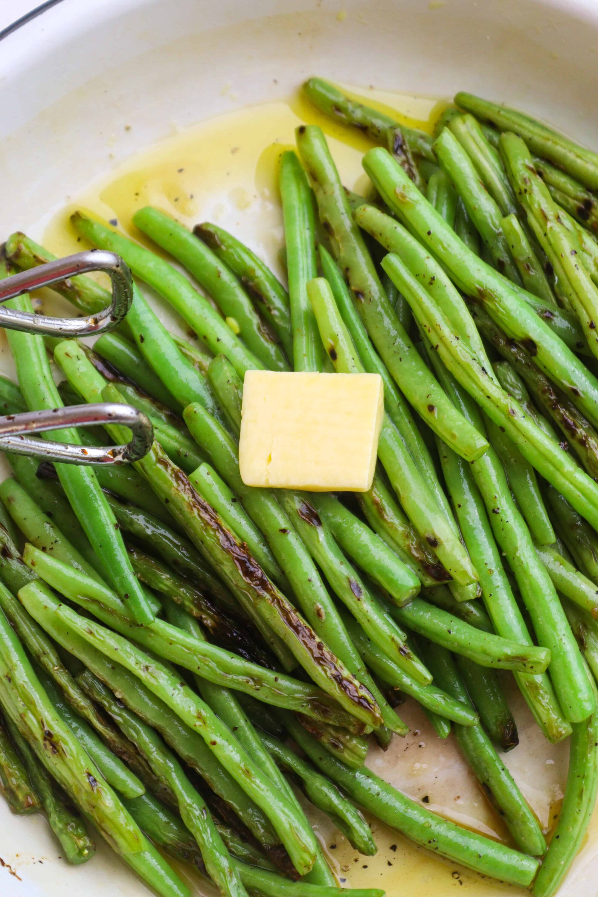 Roasted green beans with butter in a skillet, ready to serve.