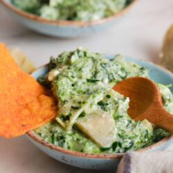 Creamy spinach artichoke dip with melted cheese and fresh herbs, served in a rustic bowl. Perfect for parties and appetizers.