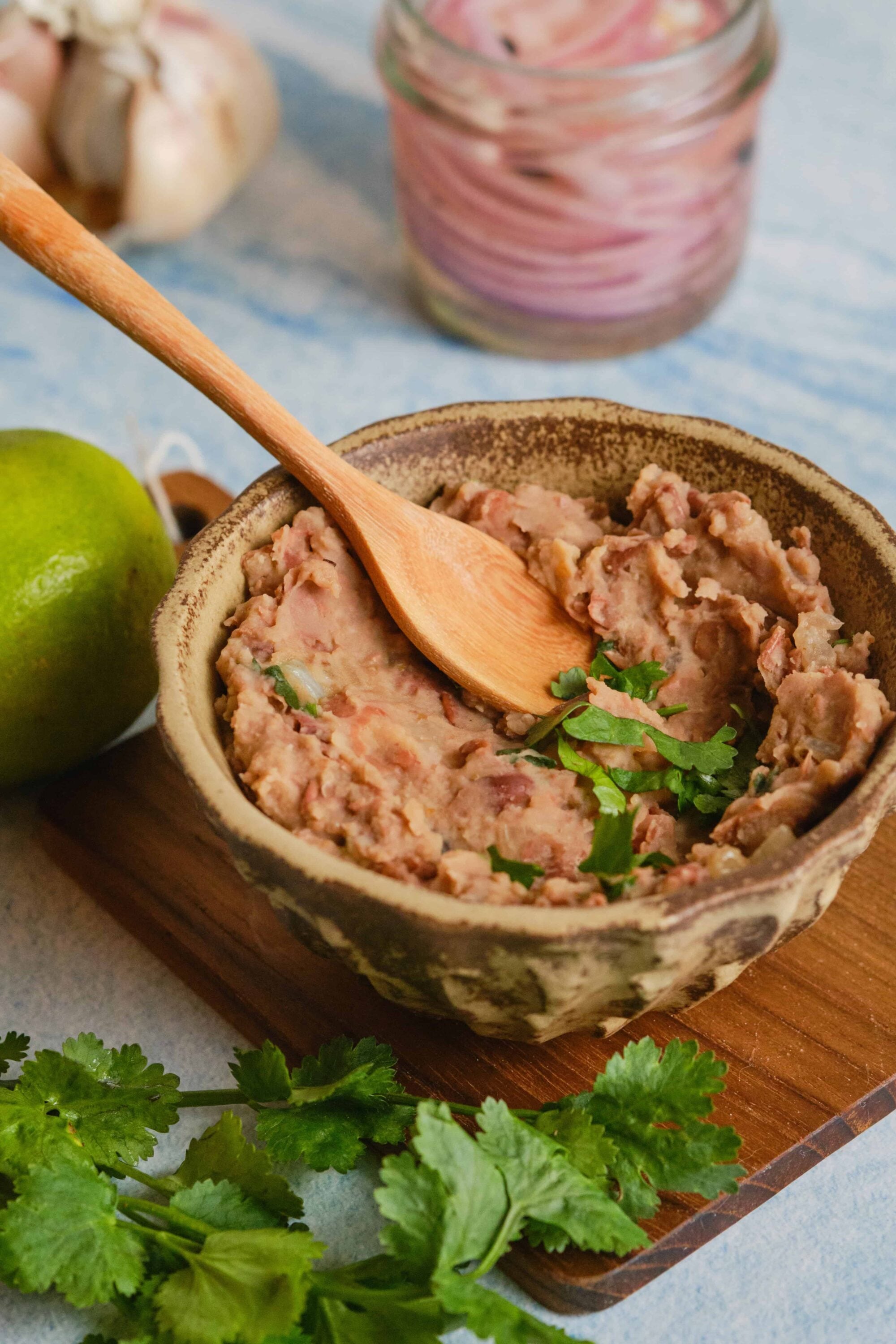 Rich, savory chicken liver pâté served in a rustic bowl with fresh herbs and lime, perfect for appetizer or spread.