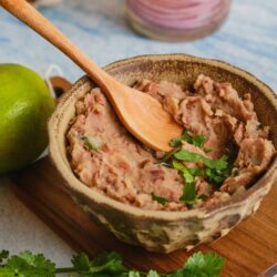 Rich, savory chicken liver pâté served in a rustic bowl with fresh herbs and lime, perfect for appetizer or spread.