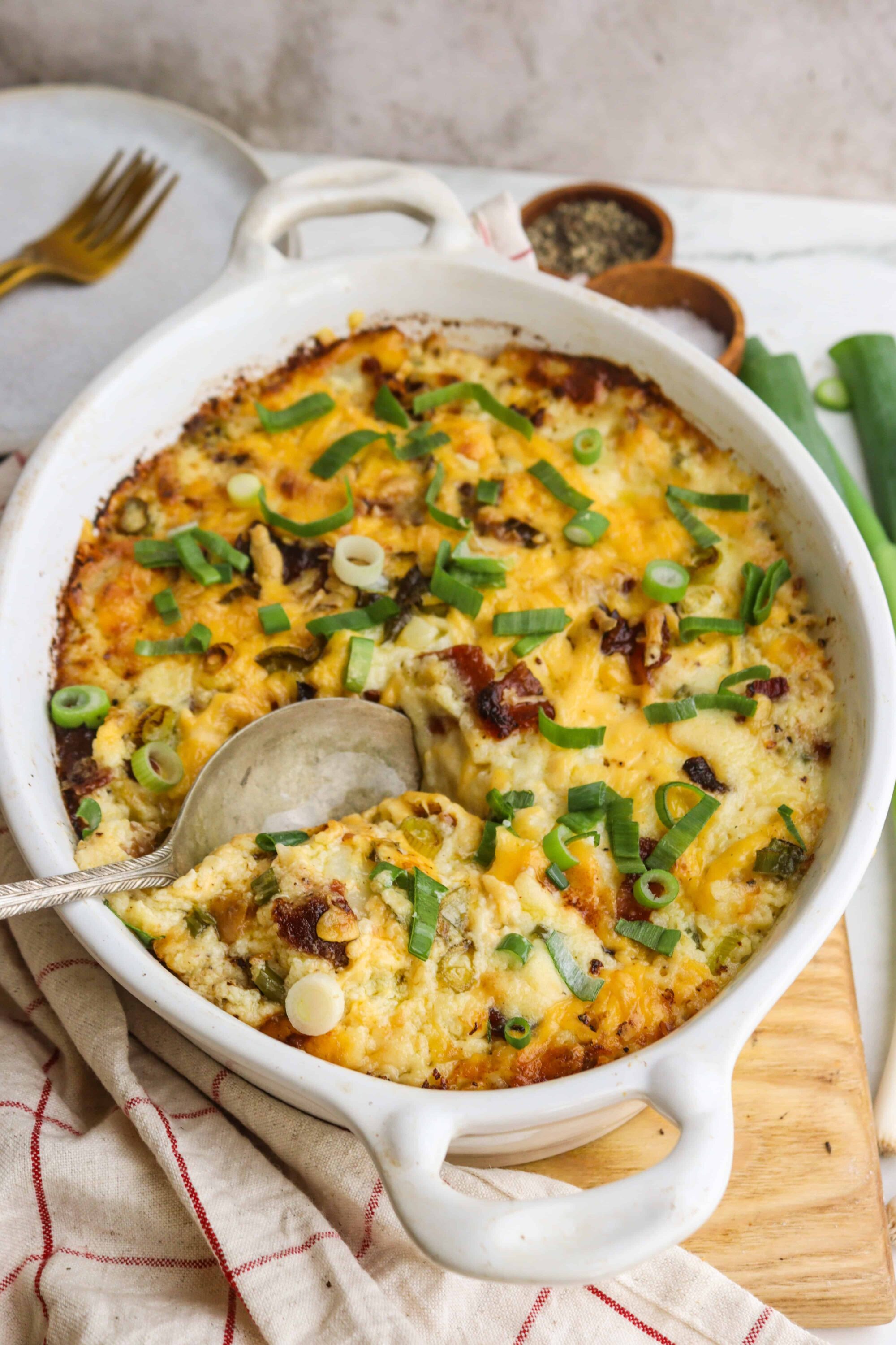Creamy baked cheese casserole with green onions and crispy bacon garnish.