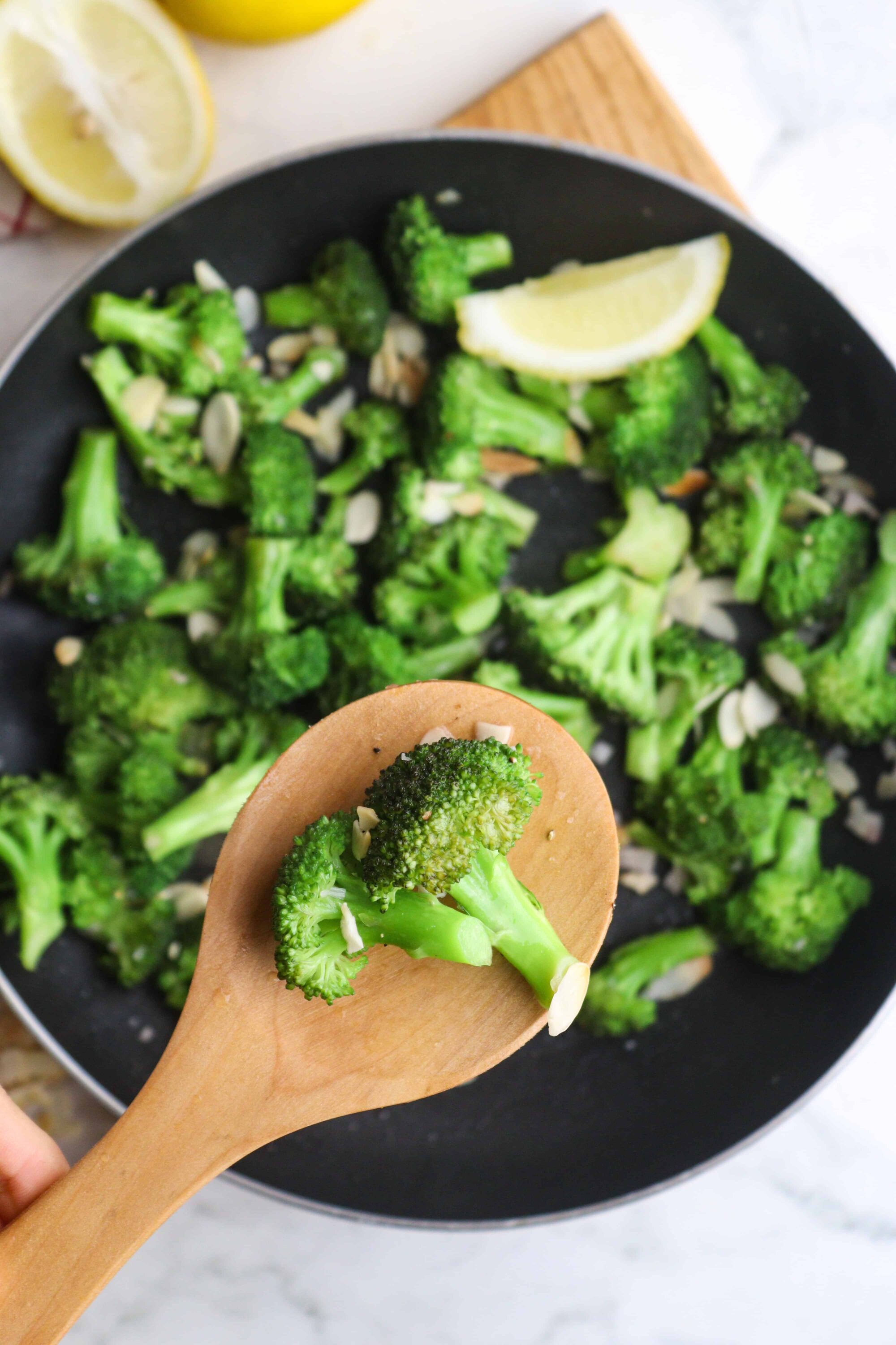 Sauteed broccoli with garlic and lemon wedges, healthy vegetable side dish.