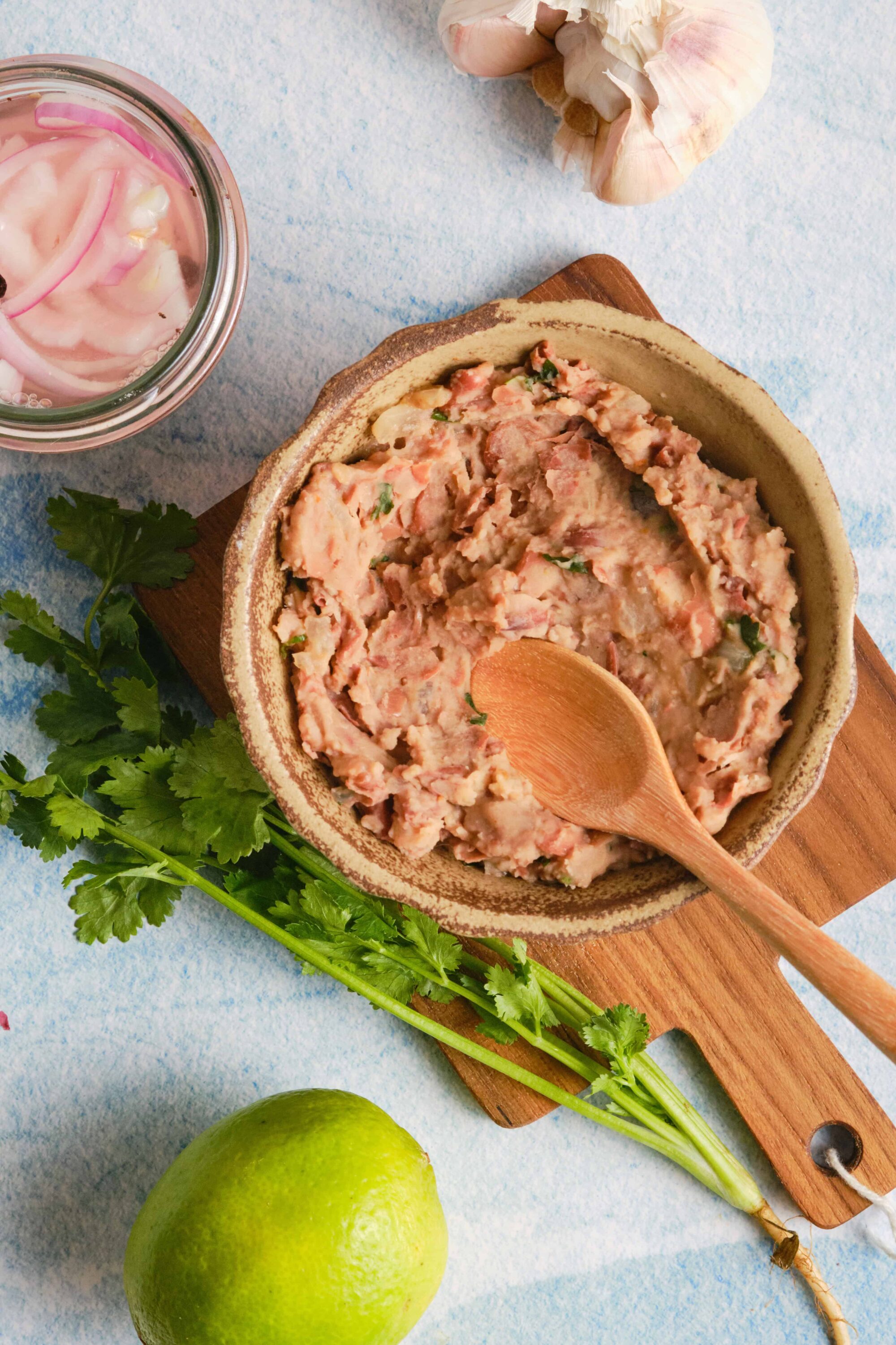 Creamy homemade chicken liver pâté with herbs and a lime on a textured blue background.