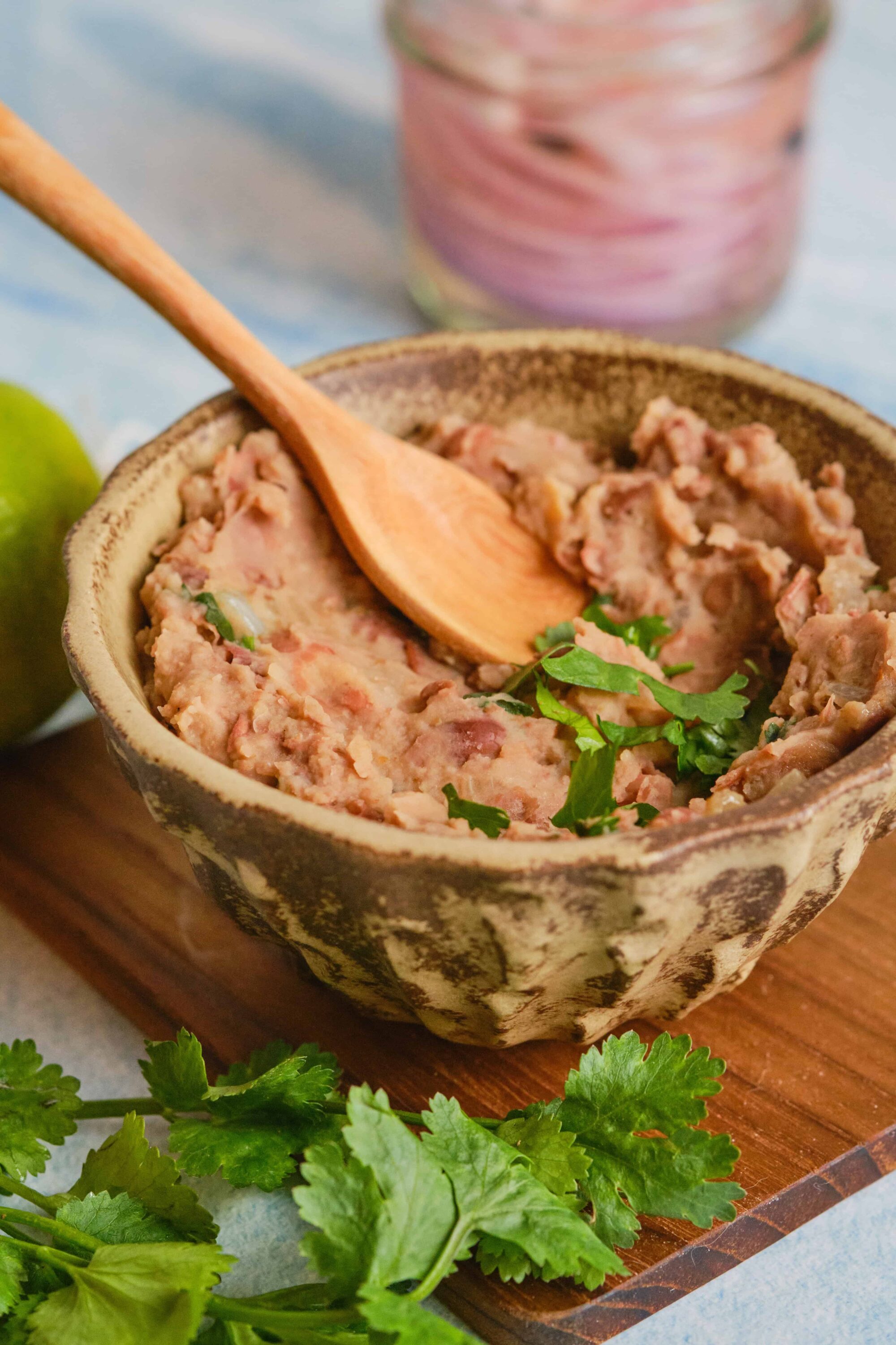 Savory homemade chicken or tuna salad in a rustic ceramic bowl on wooden board, garnished with fresh cilantro.